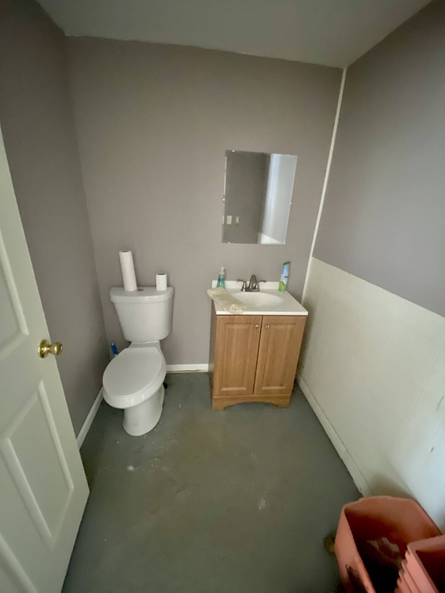 A bathroom with a toilet , sink and mirror.