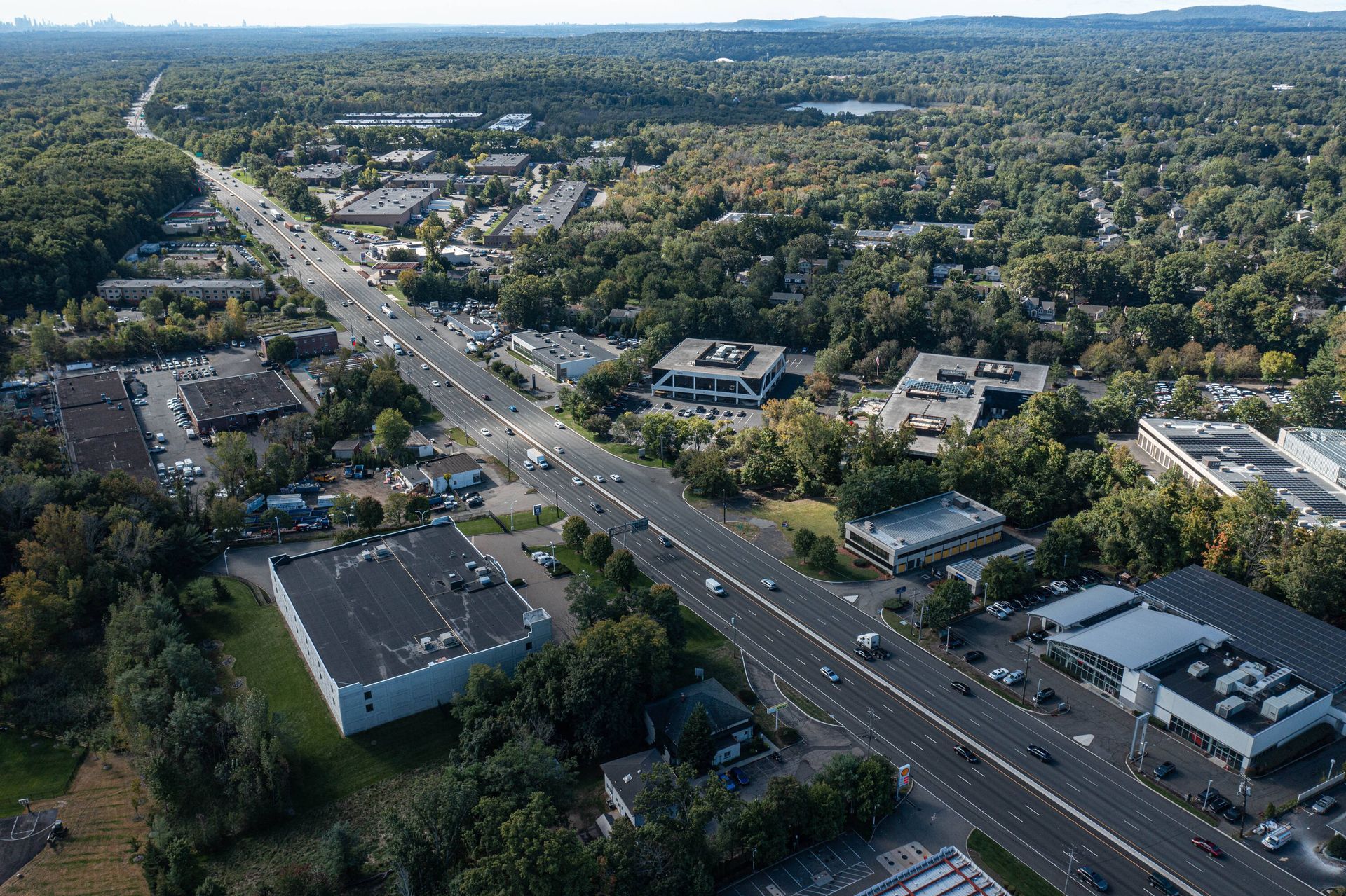 An aerial view of a highway surrounded by trees and buildings.