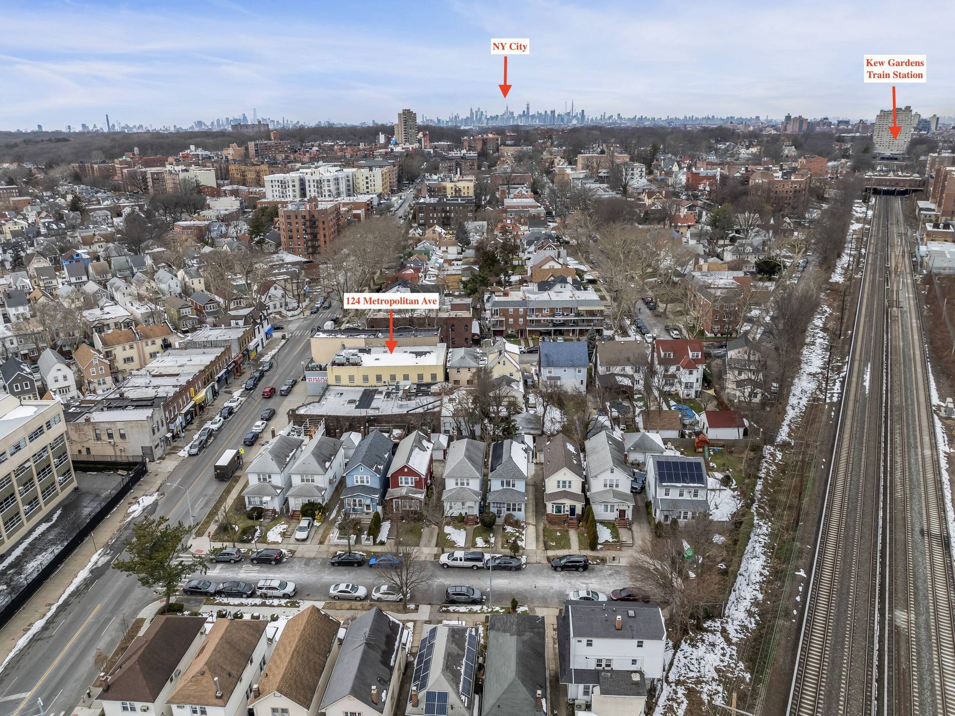 An aerial view of a city with a train track in the foreground