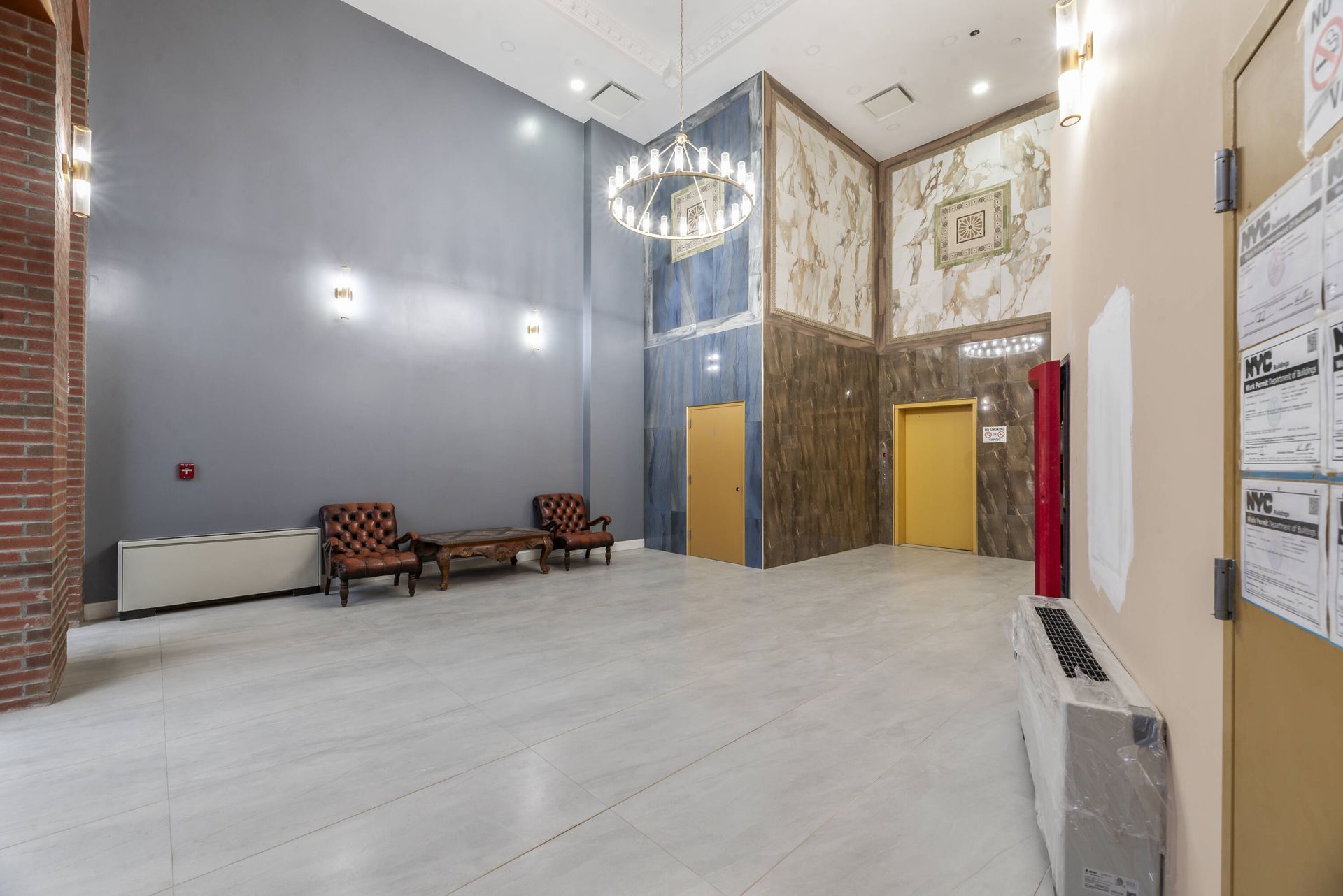 A large empty lobby with chairs and a chandelier.