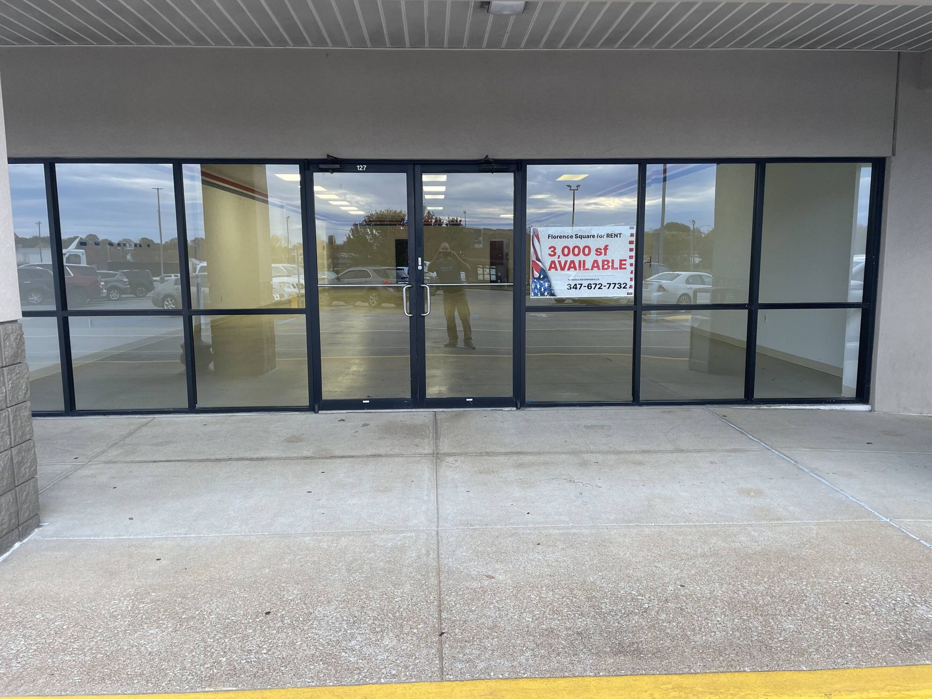 An empty store front with a sign that says ' for sale ' on it