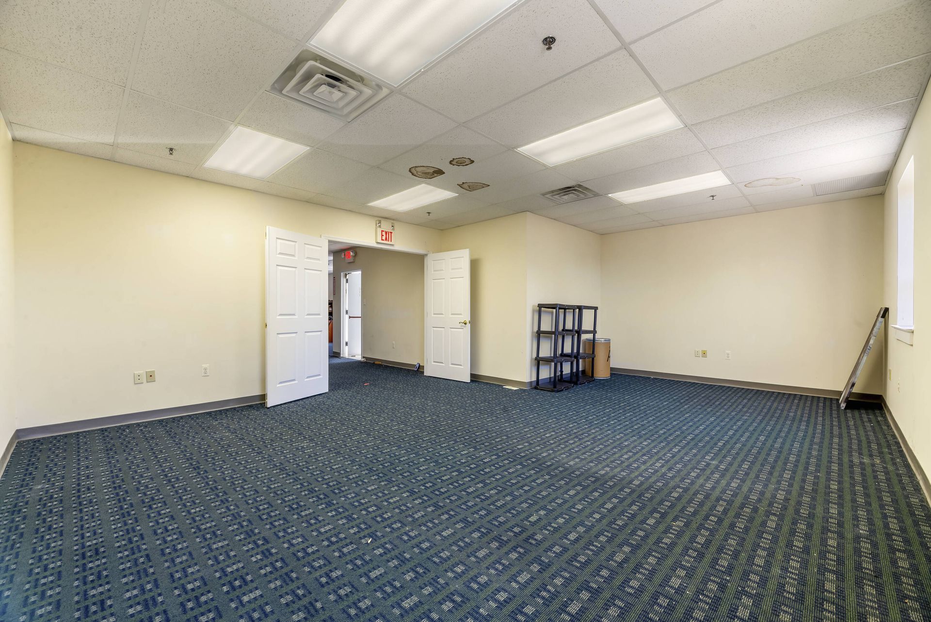 An empty room with a blue carpet and white walls.