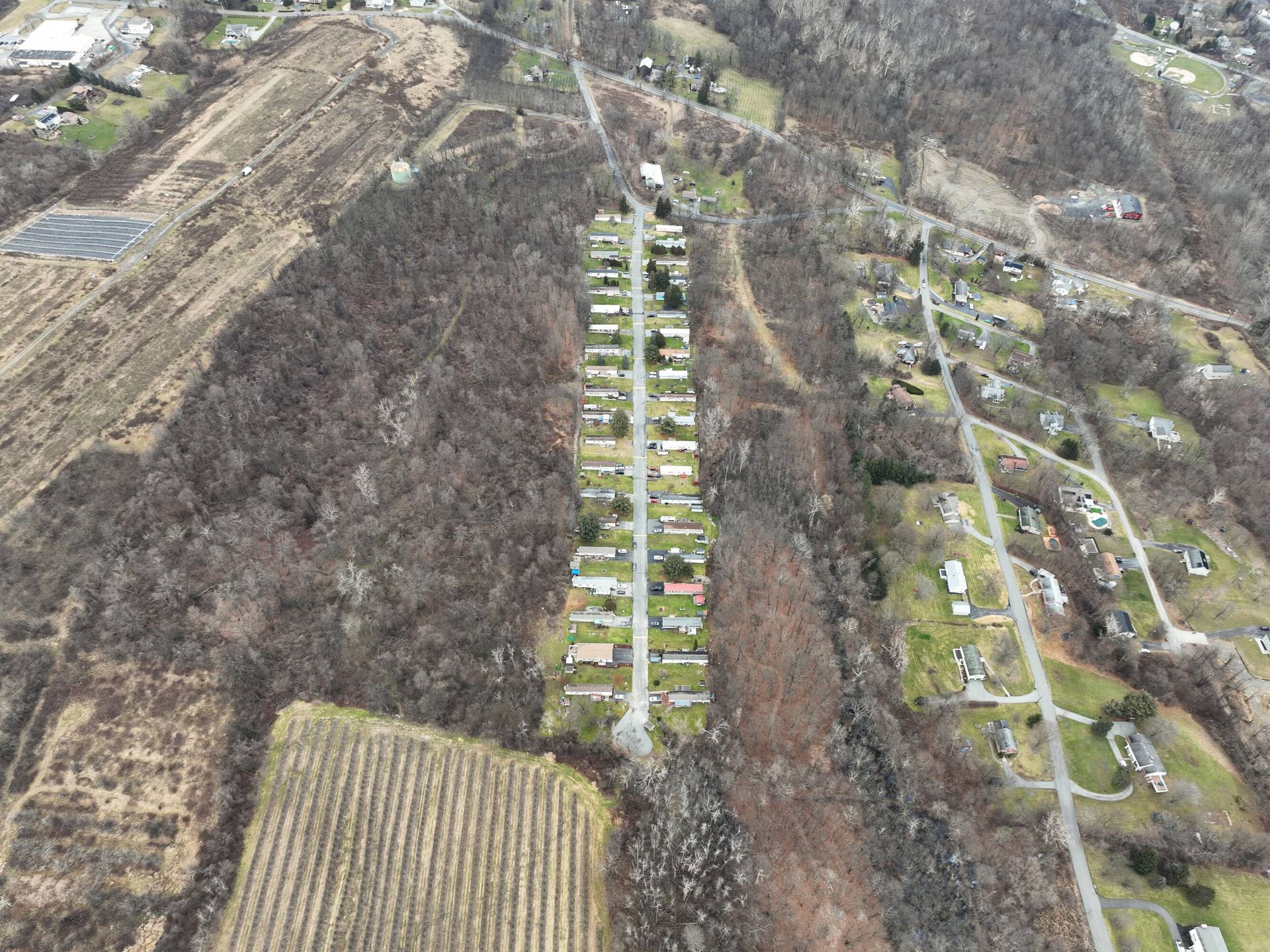 An aerial view of a residential area surrounded by trees and fields.