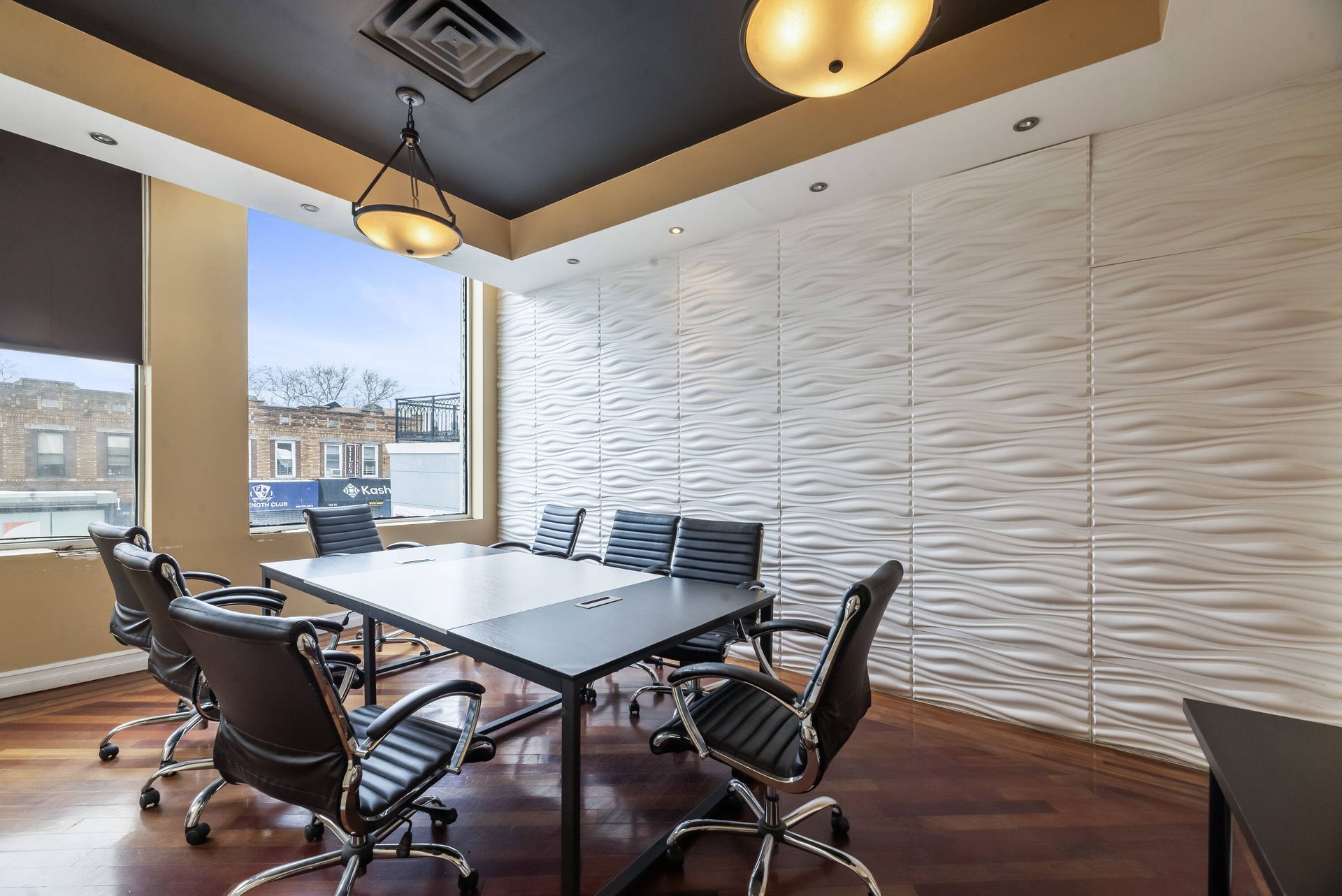 A conference room with a table and chairs and a window.