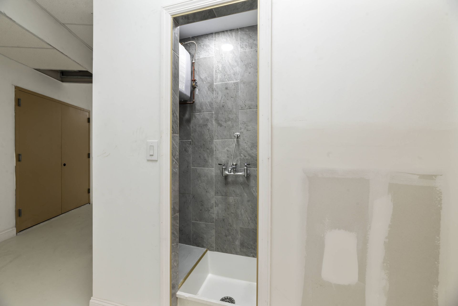 A bathroom with a walk in shower and a sink.