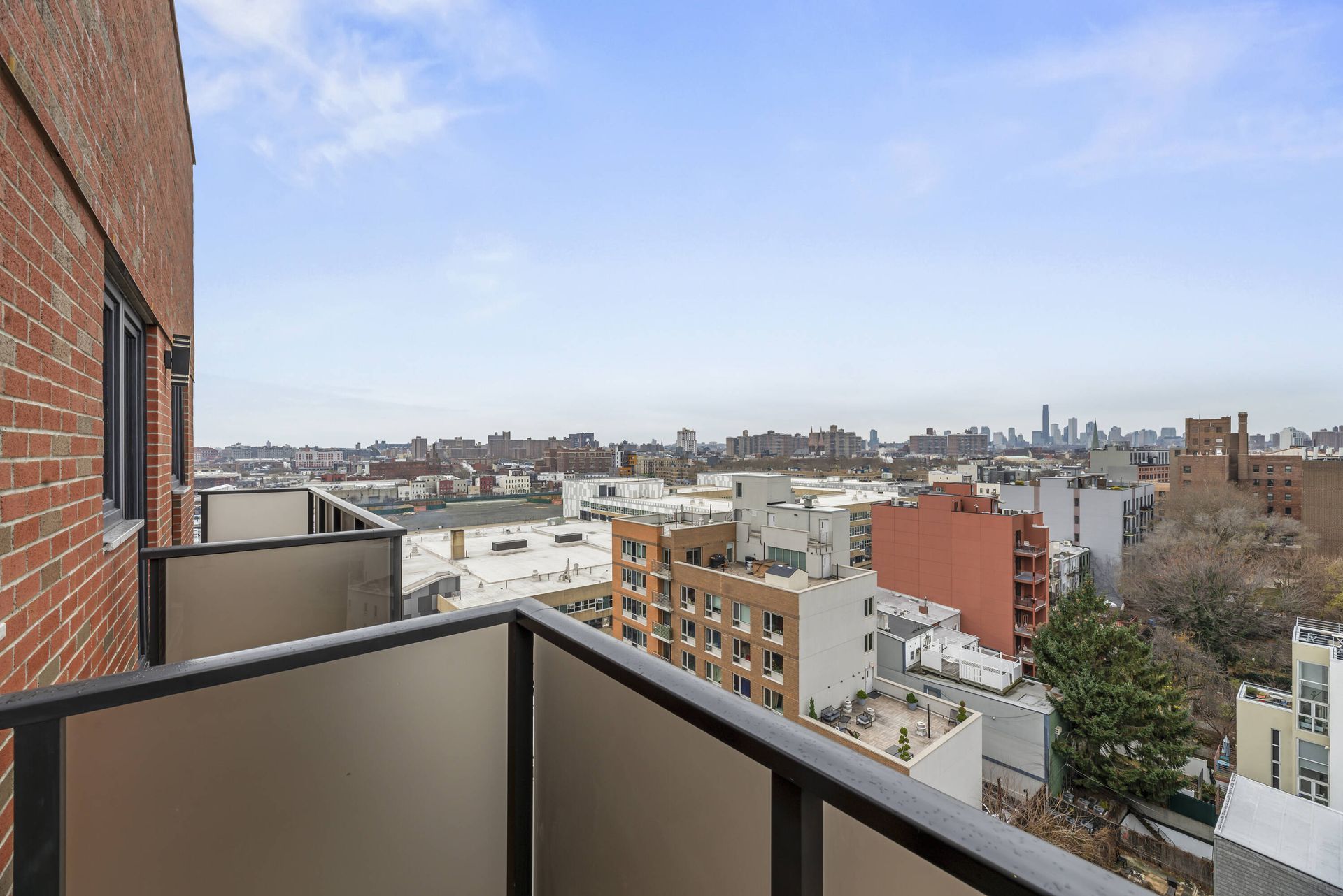 A balcony with a view of a city from a brick building.