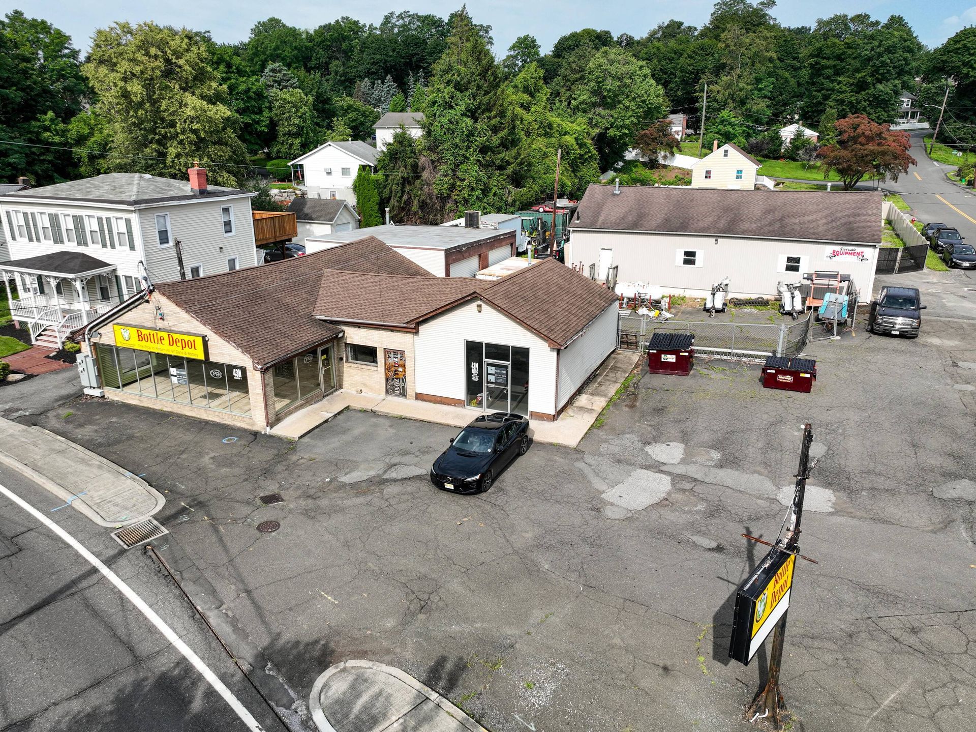 An aerial view of a small town with a car parked in front of a building.