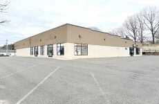 A large building with a lot of windows and a parking lot in front of it.