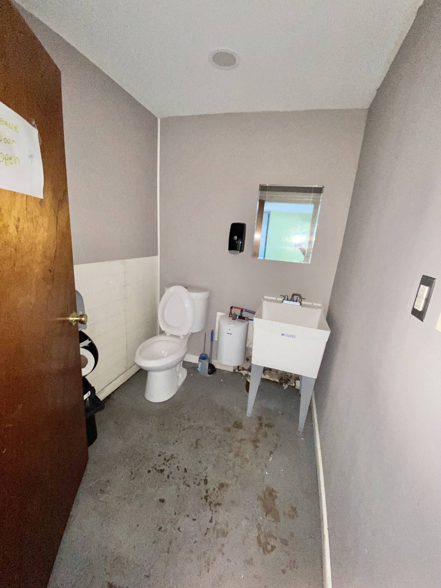A bathroom with a toilet , sink and mirror