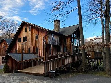 A large wooden house with a ramp leading to it.