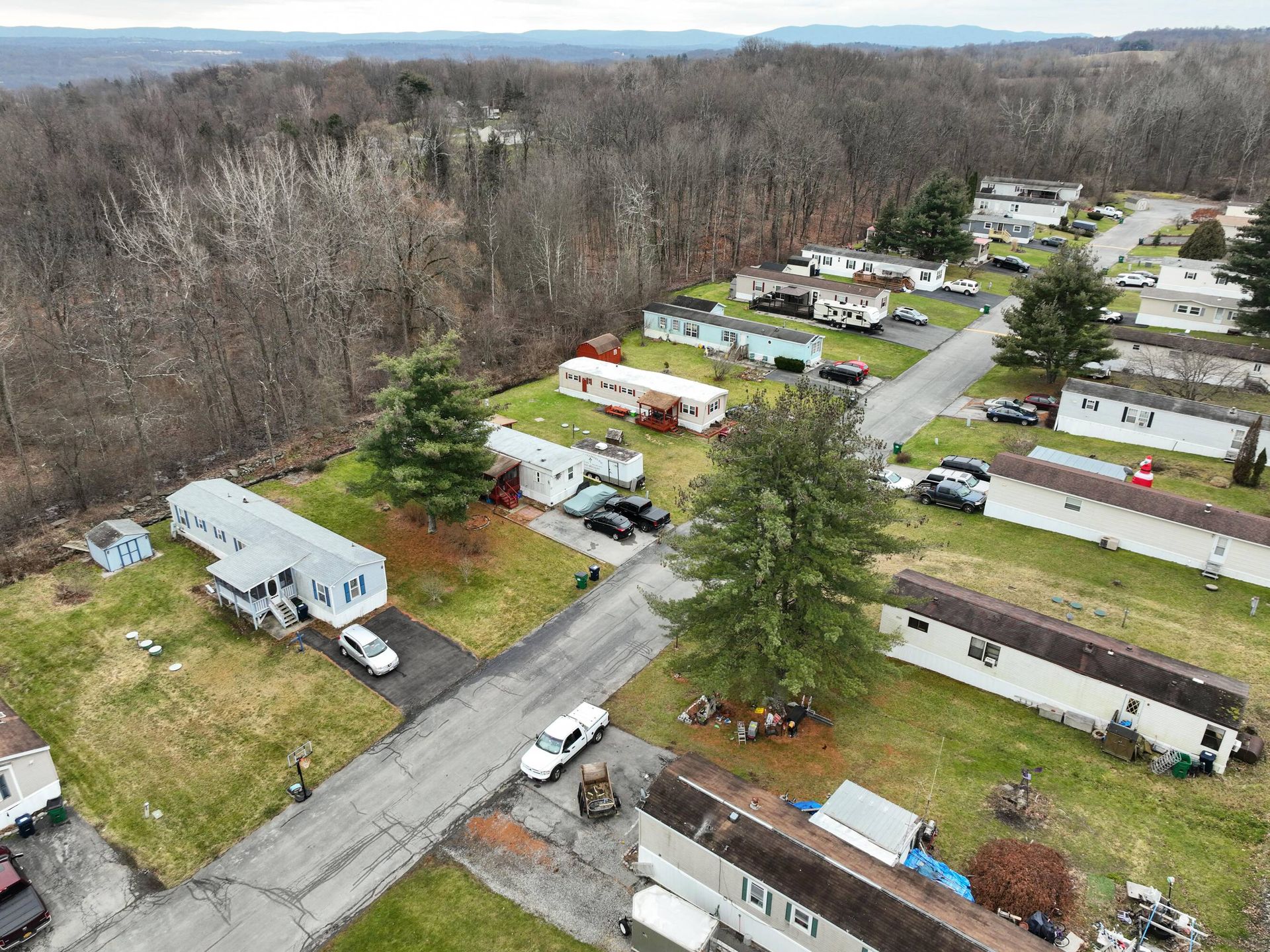 An aerial view of a mobile home park in the woods.
