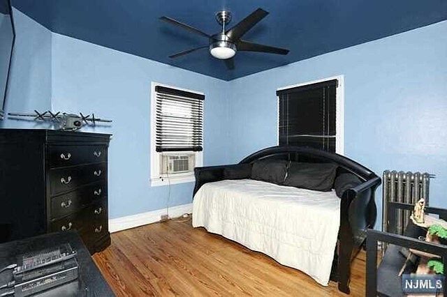 A bedroom with a couch and a ceiling fan