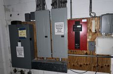 A room with a lot of electrical panels on the wall.