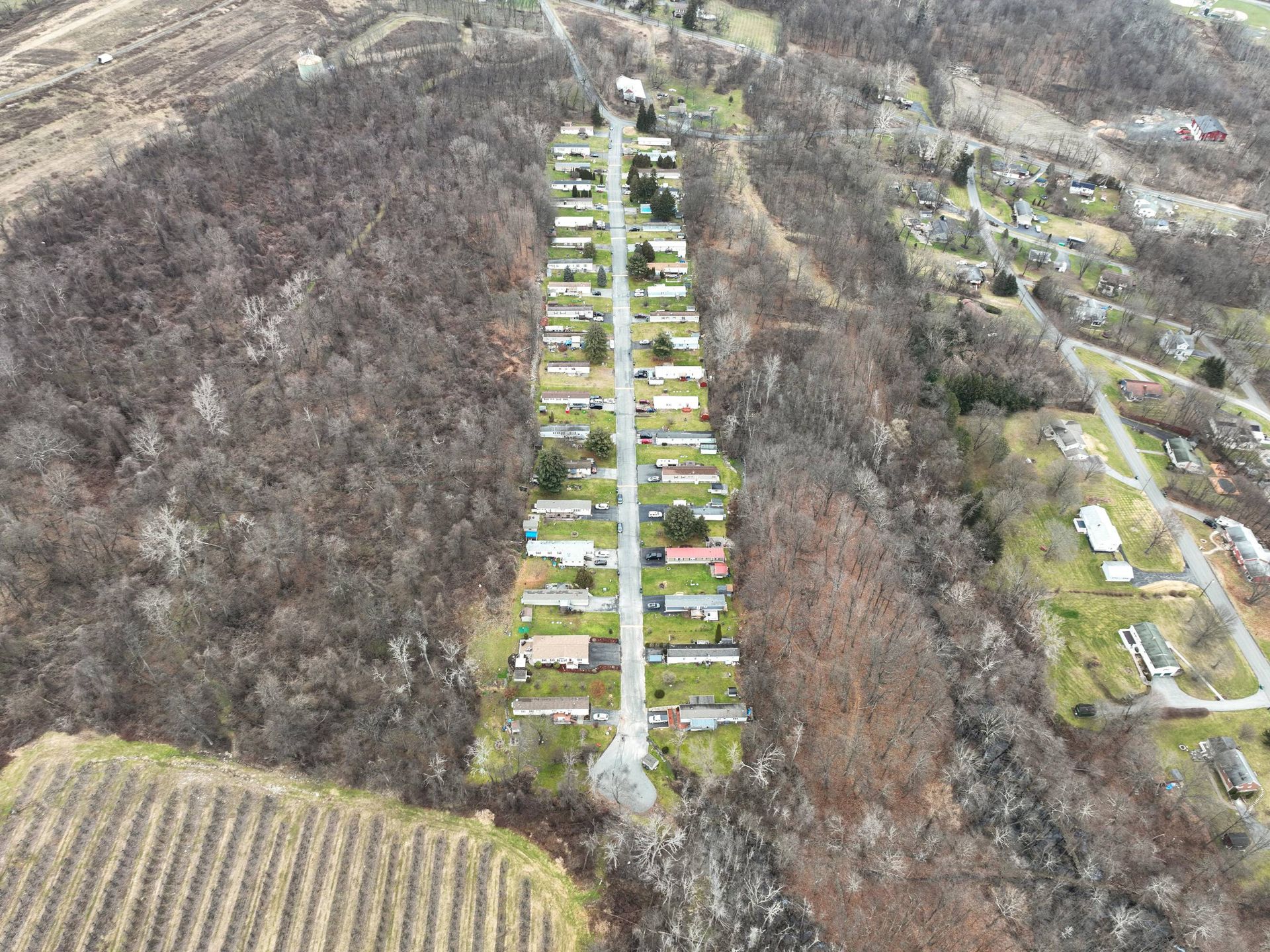 An aerial view of a mobile home park in the middle of a forest.