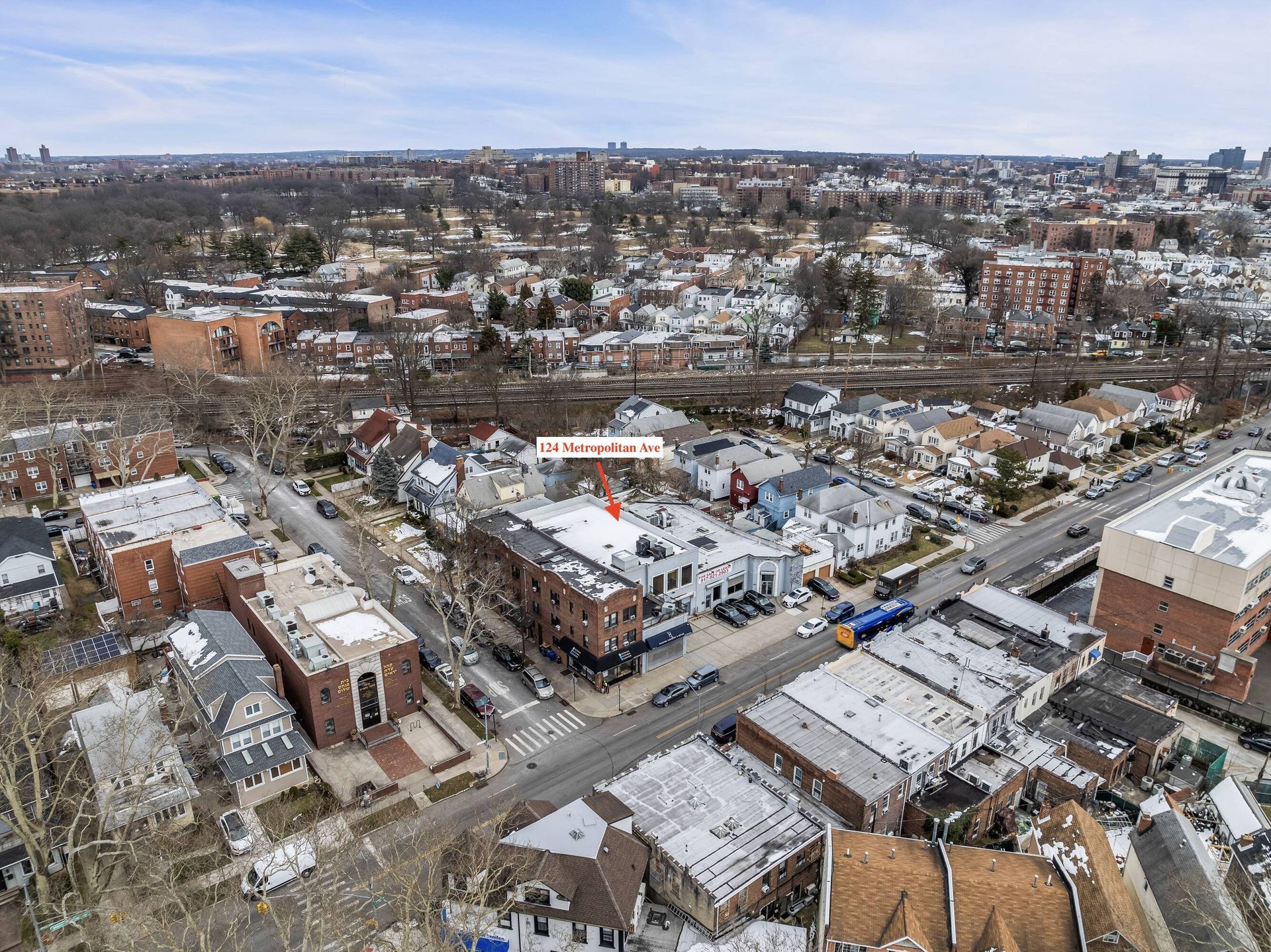 An aerial view of a city with a red arrow pointing to a building.