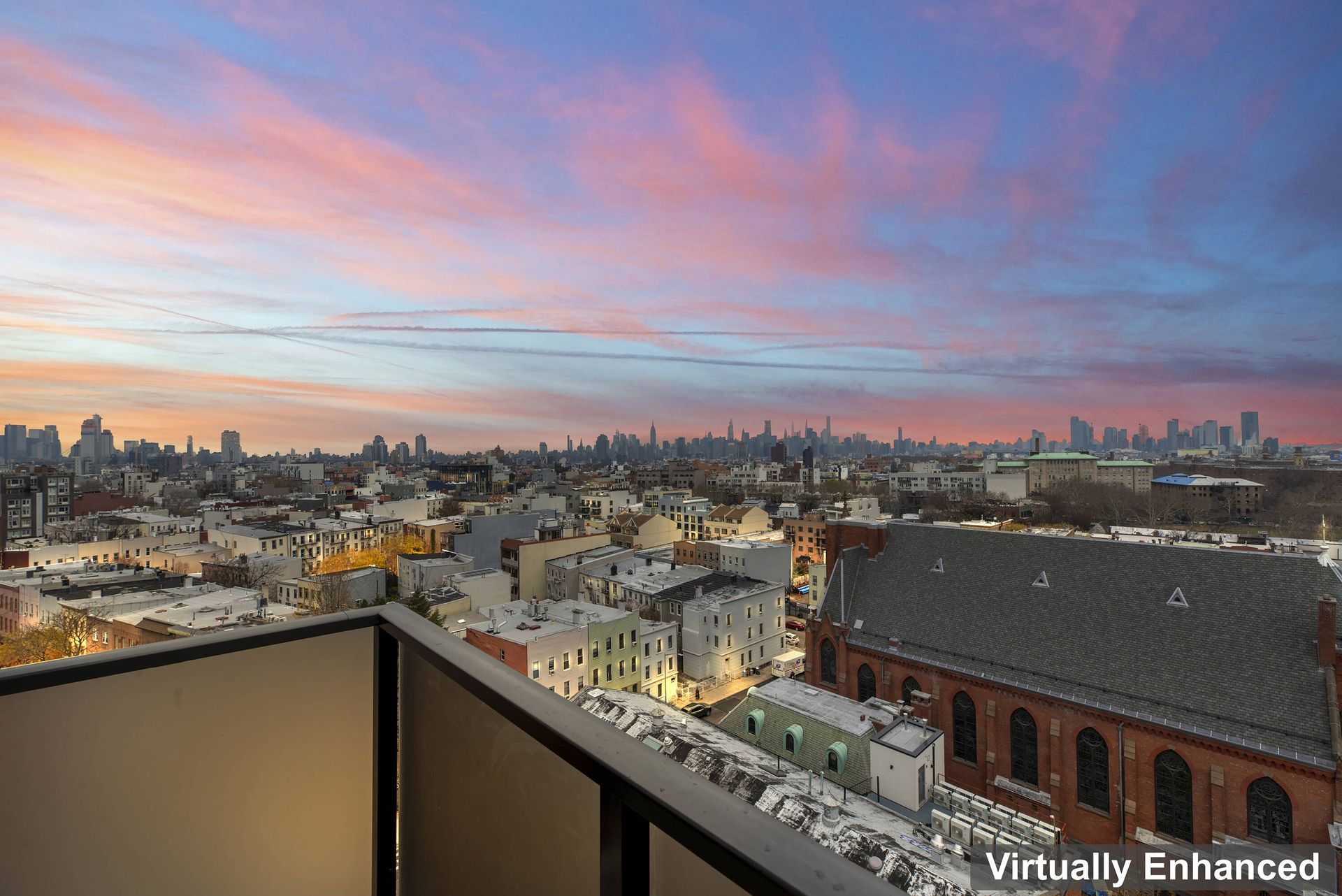 A view of a city from a balcony at sunset