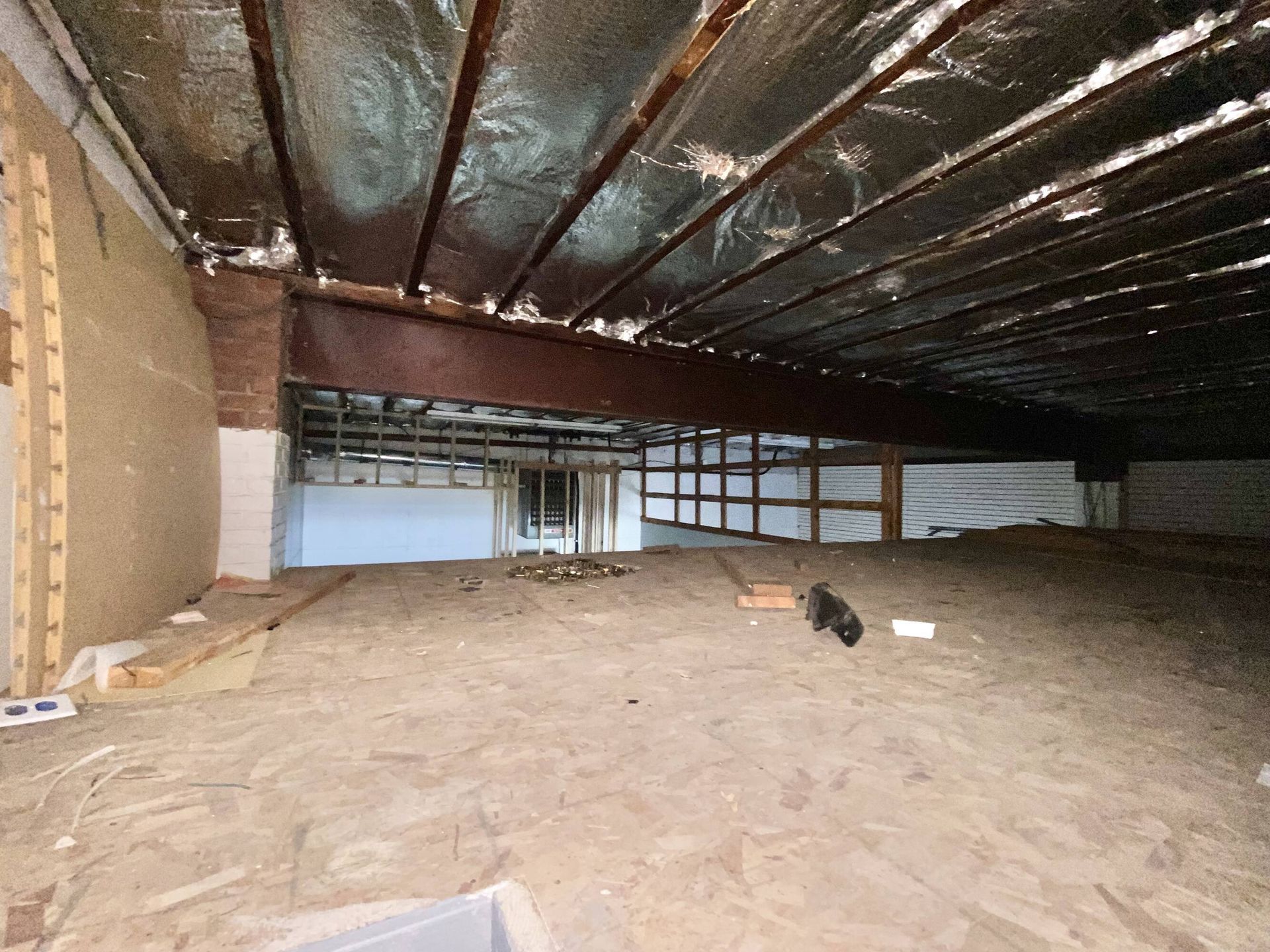 A large empty room with a ceiling that is covered in insulation.