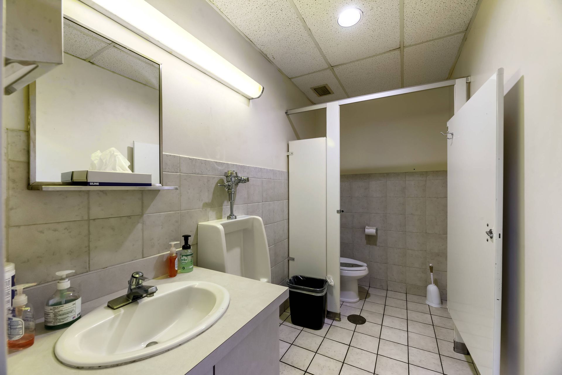 A bathroom with a sink a toilet and a urinal
