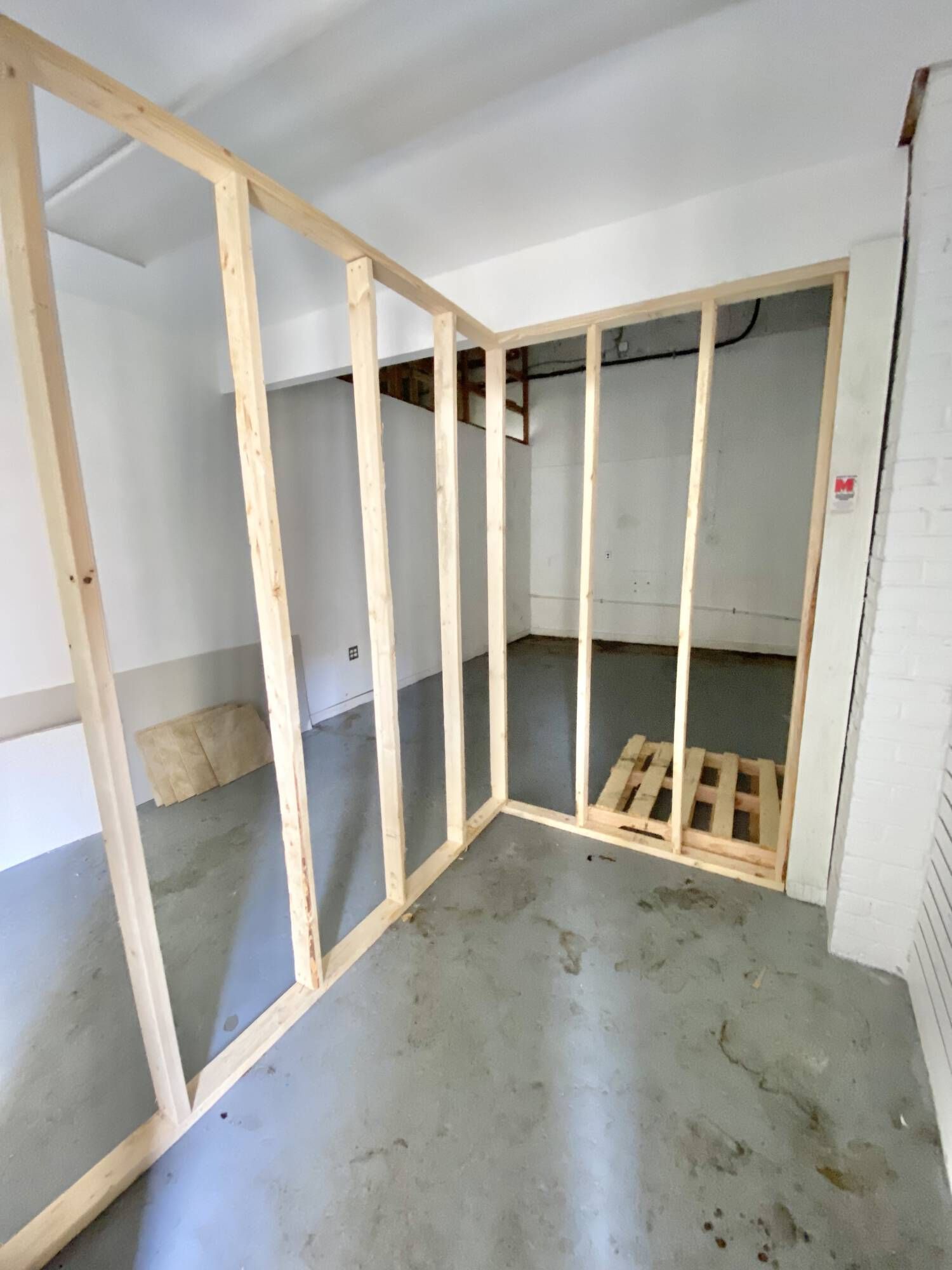 A room with wooden walls and a pallet on the floor