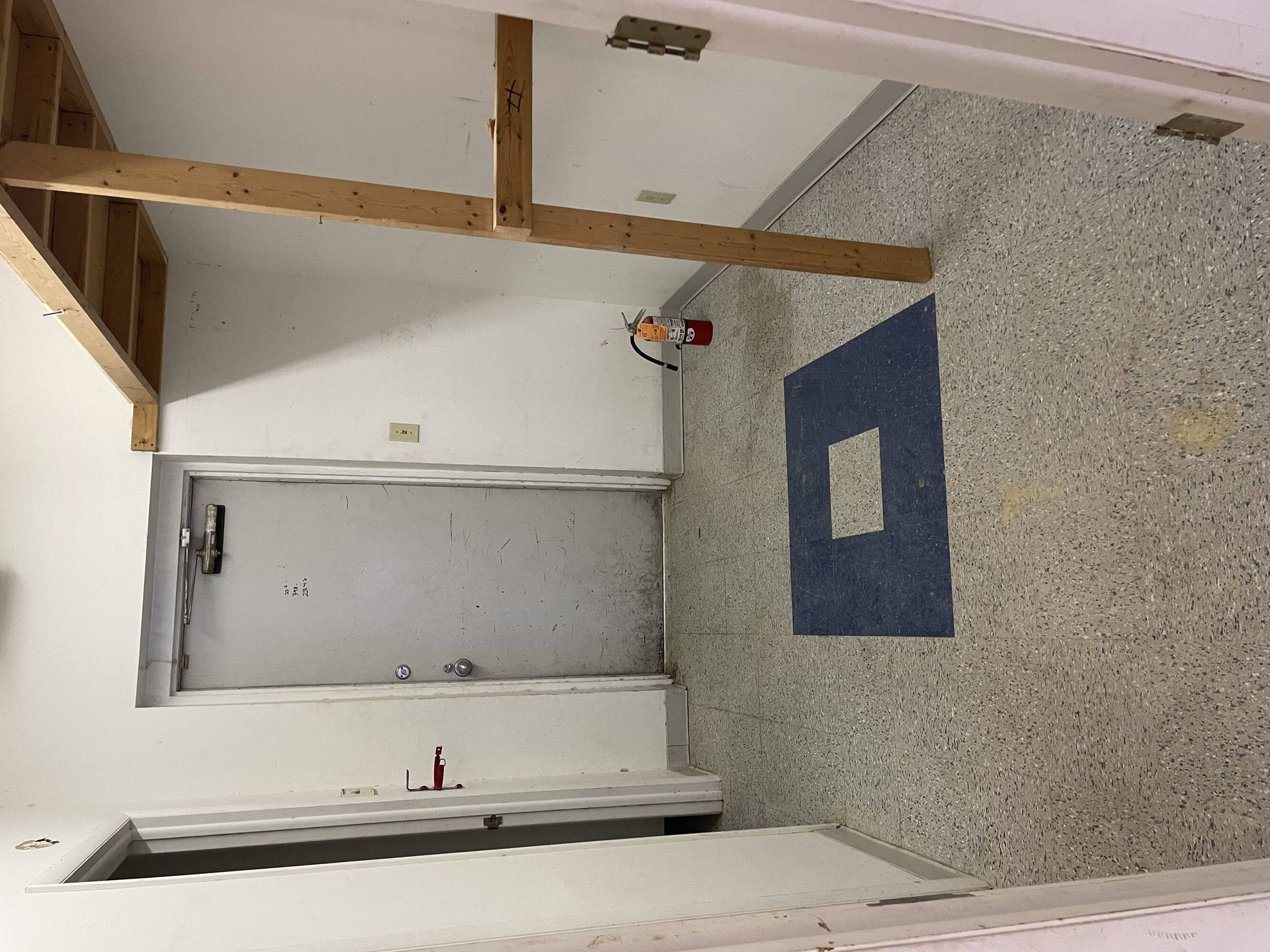 A room with a door and a blue rug on the floor