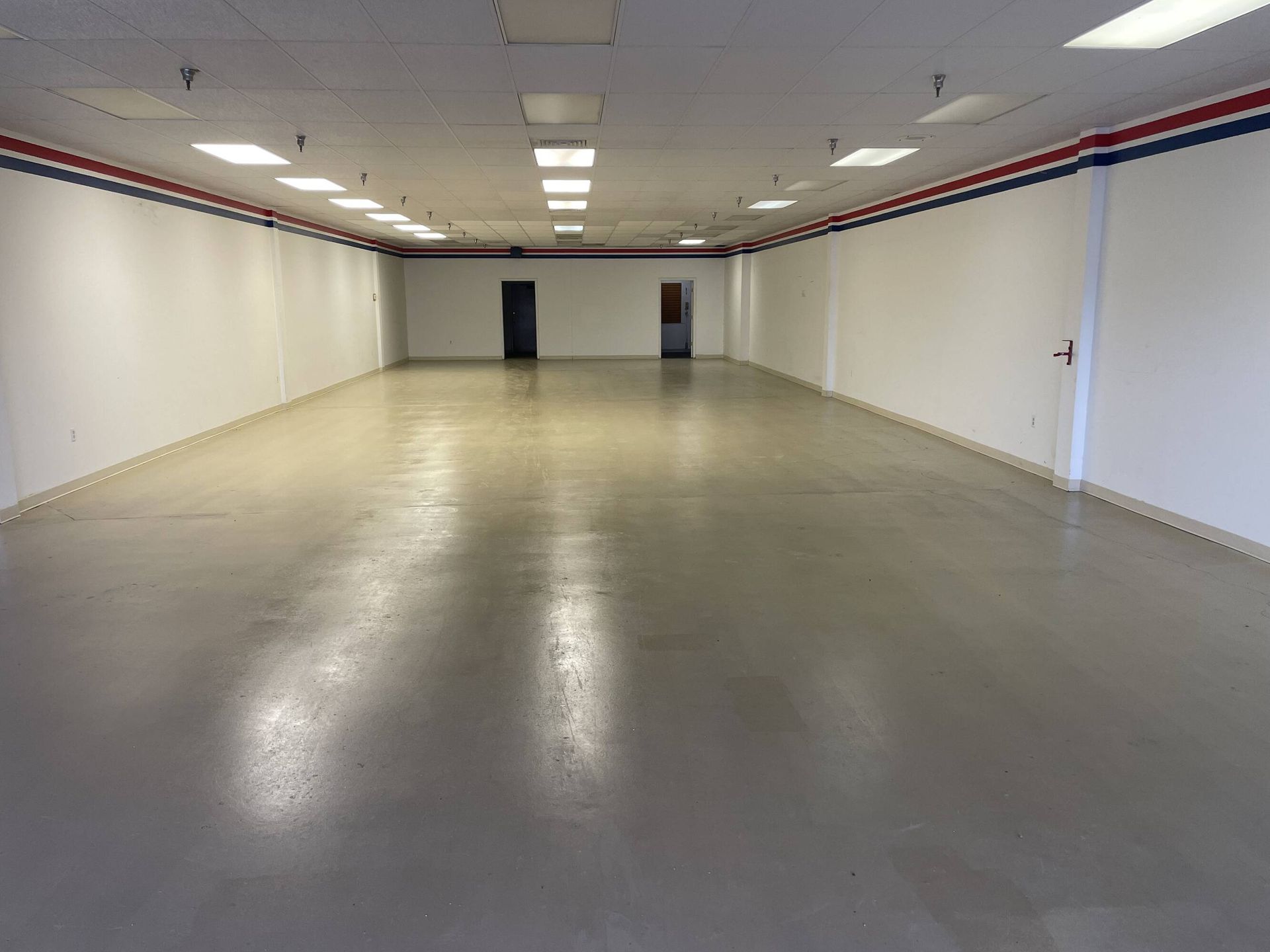 A large empty room with a gray floor and white walls.