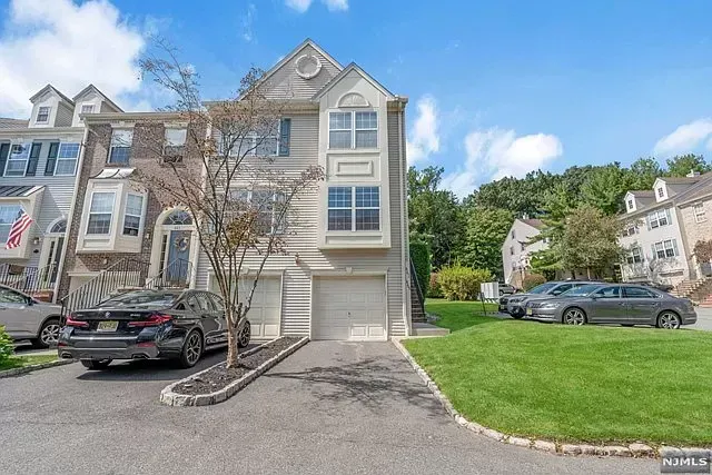 A house with a lot of cars parked in front of it.