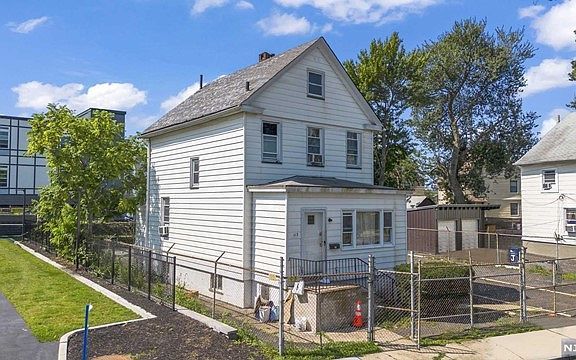 An aerial view of a white house with a fence around it.