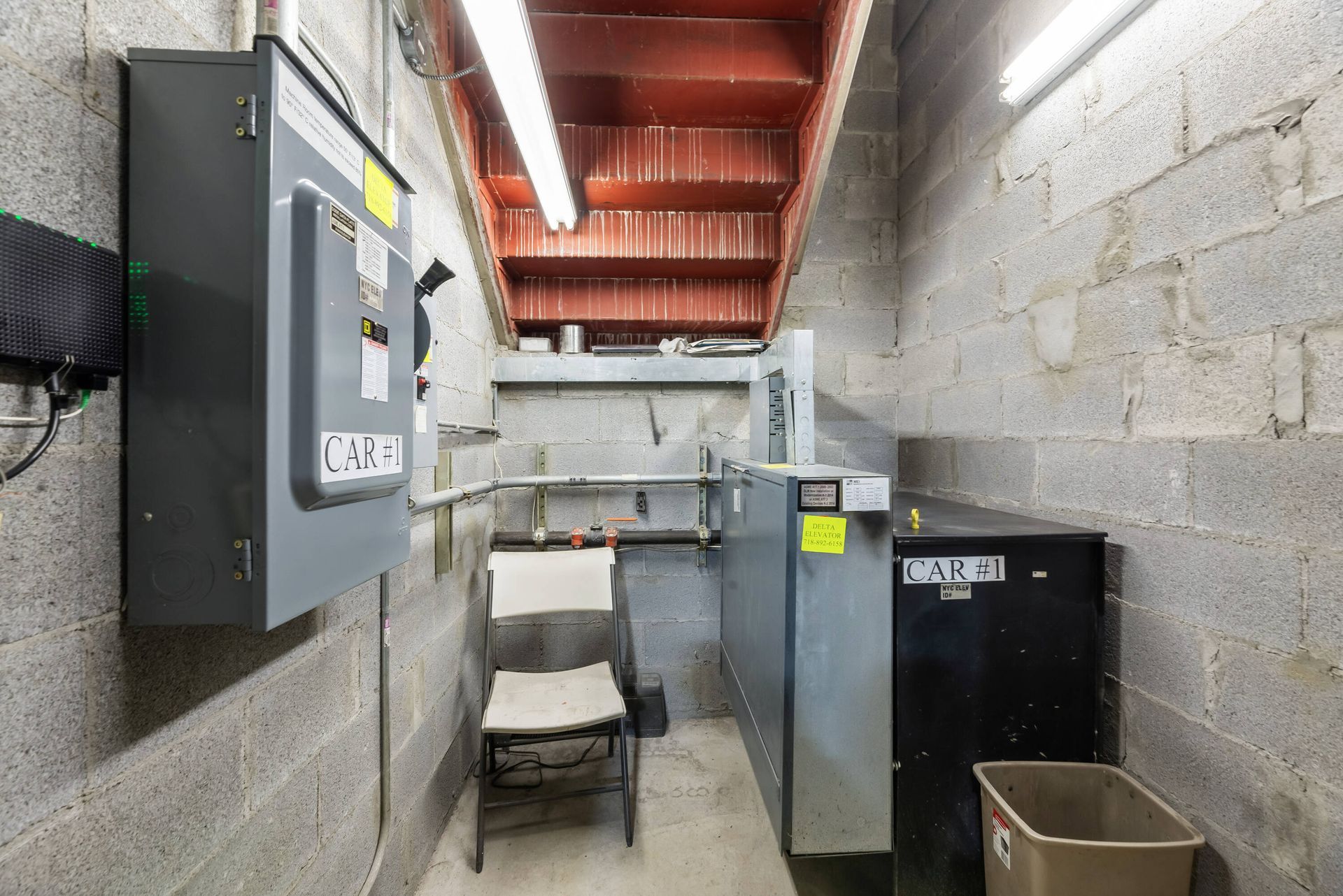 A room with a chair and a trash can in it
