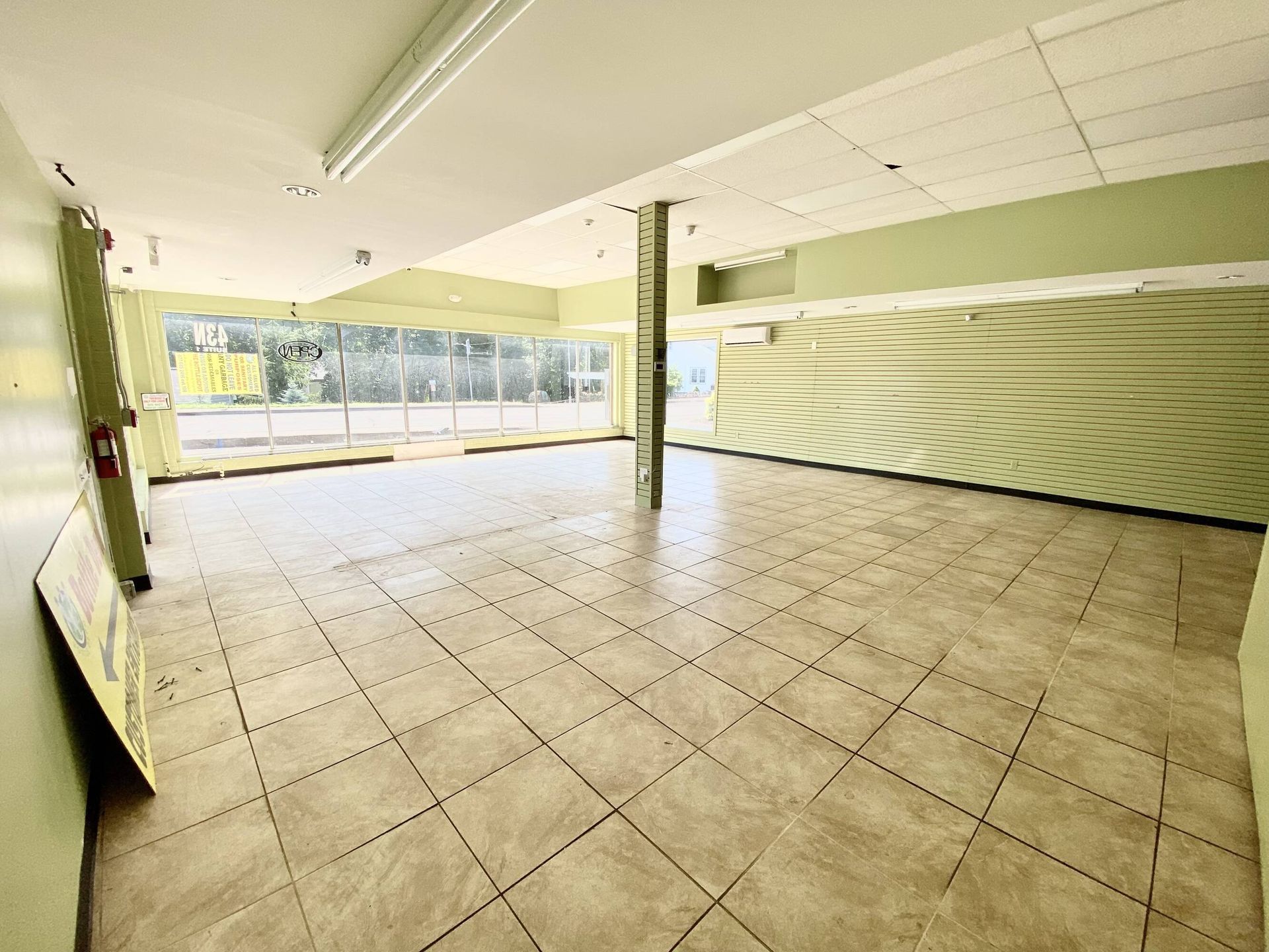 An empty room with a tiled floor and green walls