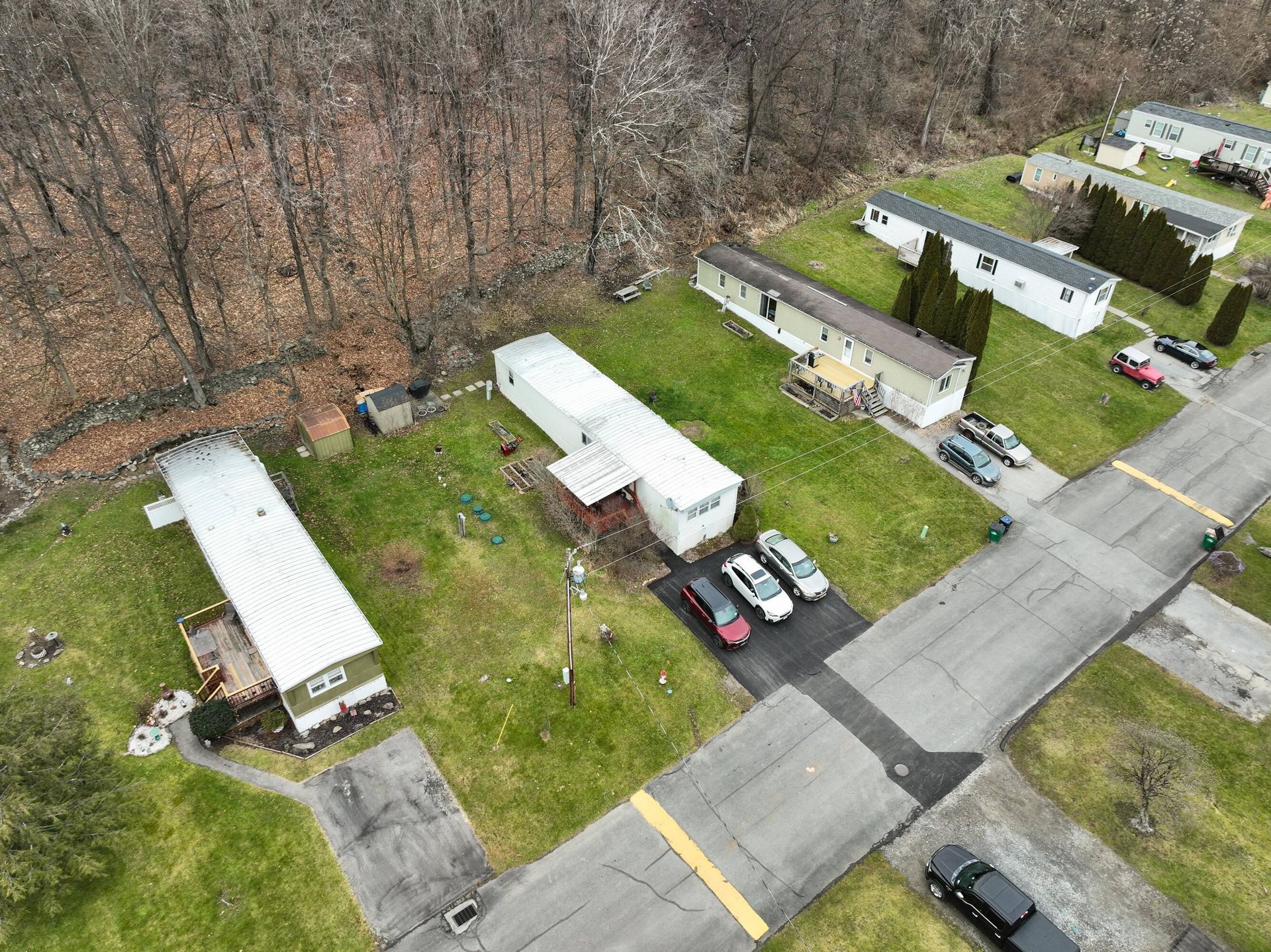 An aerial view of a mobile home park with cars parked on the side of the road.