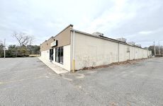 A large white building with a parking lot in front of it.