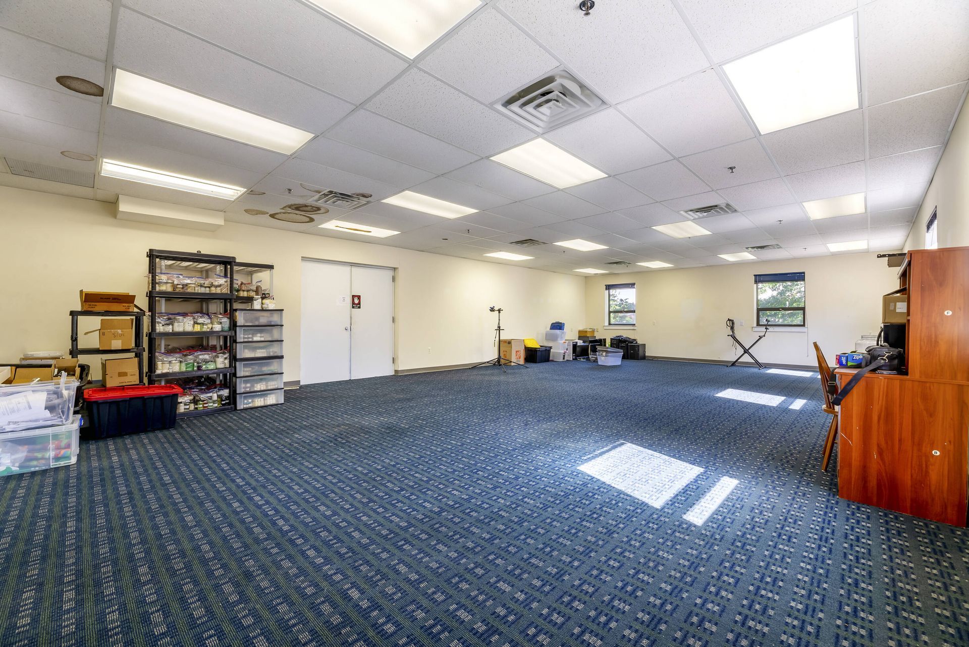 A large empty room with a blue carpet and white walls.