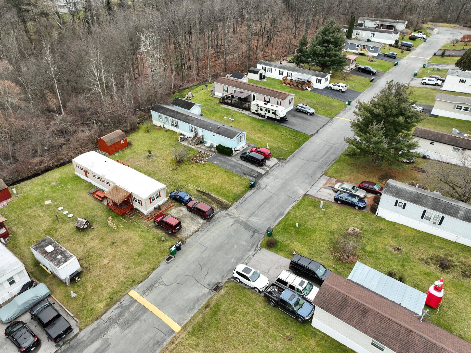 An aerial view of a mobile home park with lots of cars parked on the side of the road.
