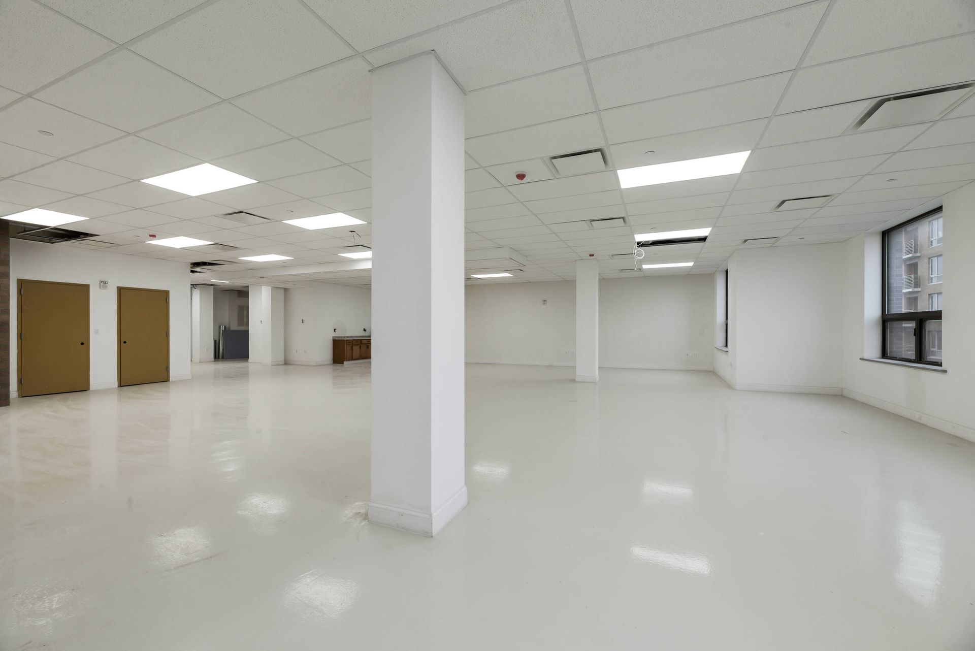 A large empty room with white walls and columns.