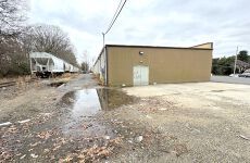 A train is parked next to a building next to a puddle of water.