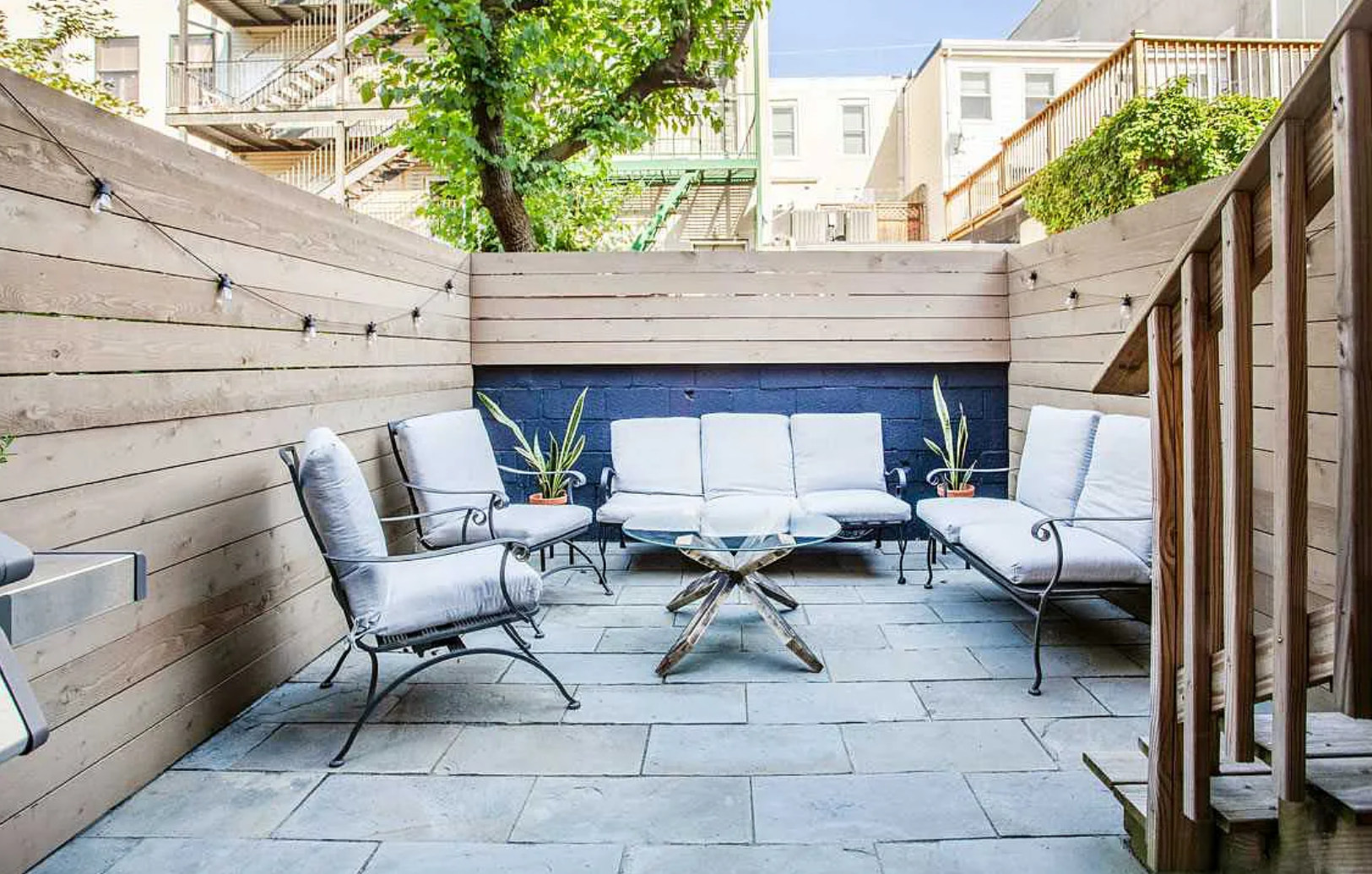 A patio with a couch , chairs , and a table.