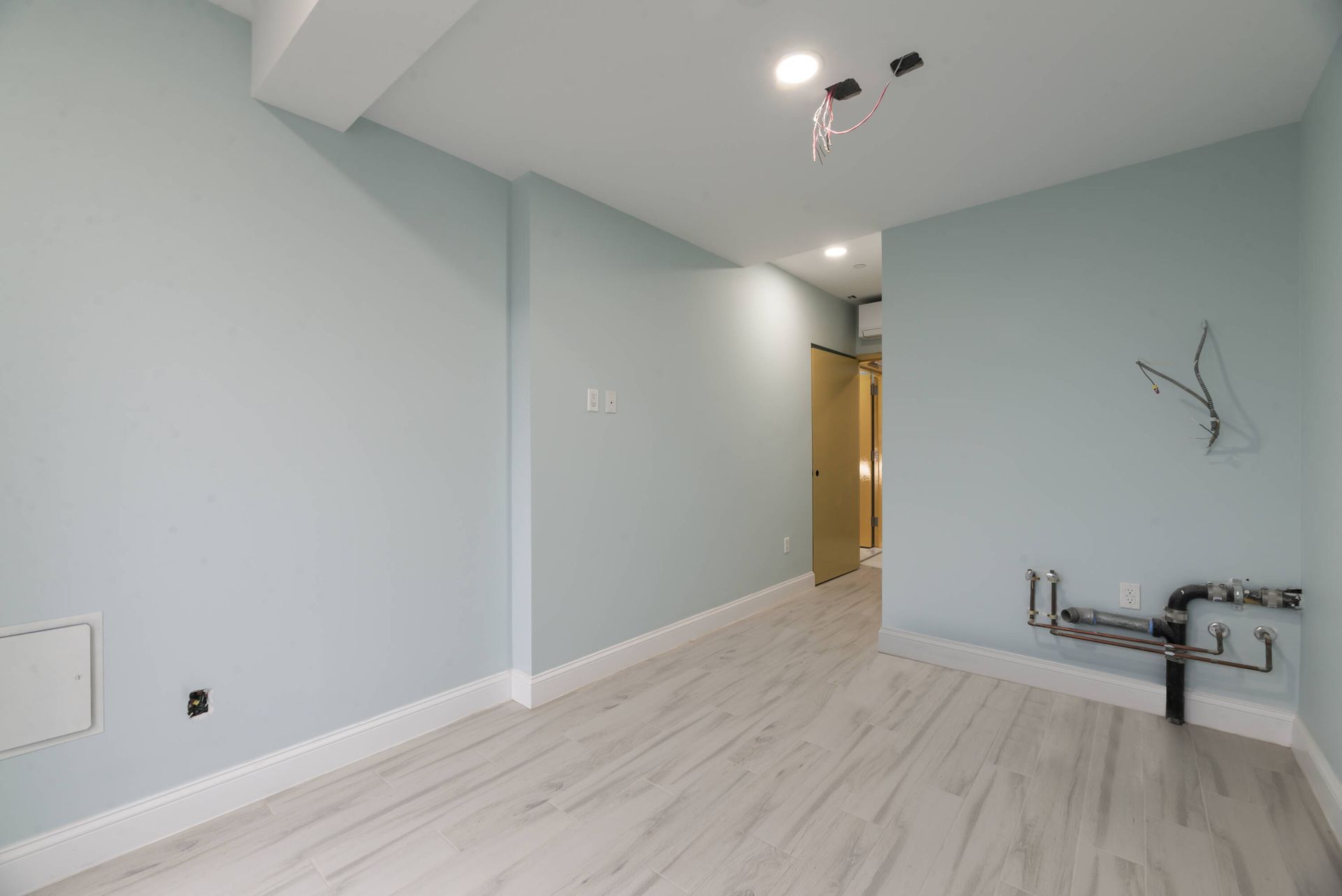 An empty room with light blue walls and white trim
