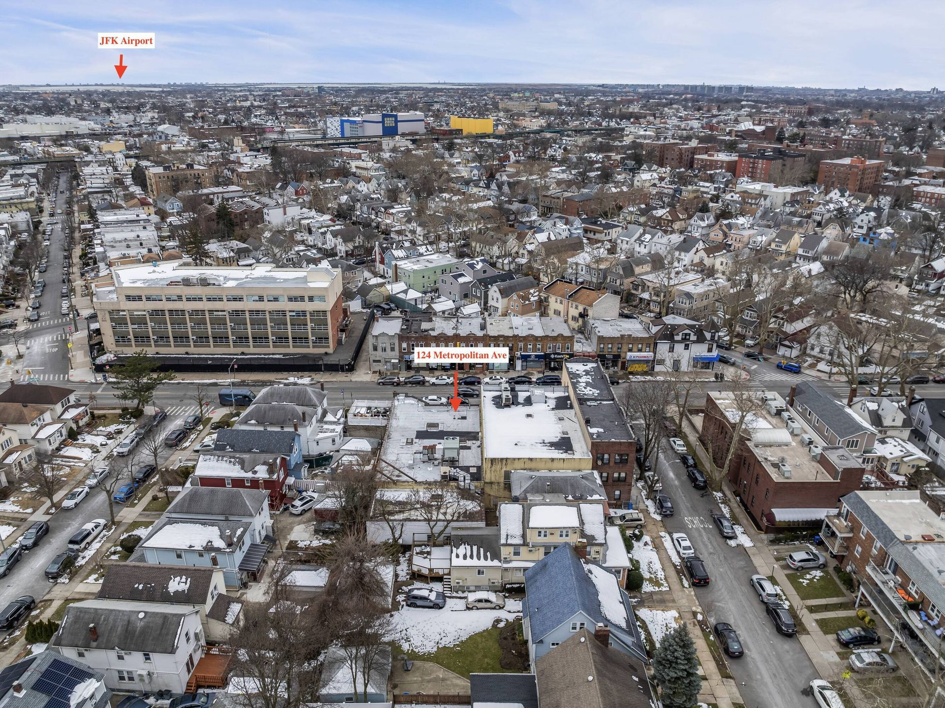 An aerial view of a city with a building in the middle of it.