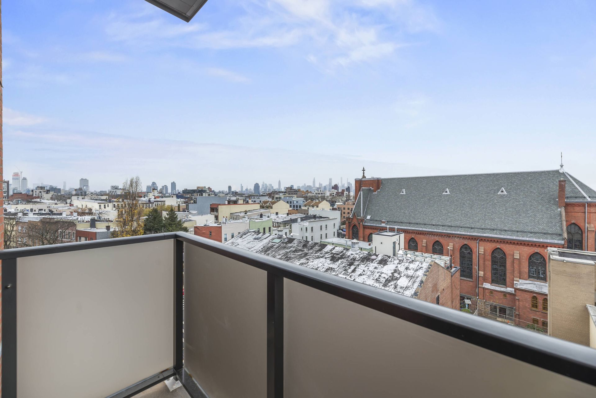 A balcony with a view of a city and a church.