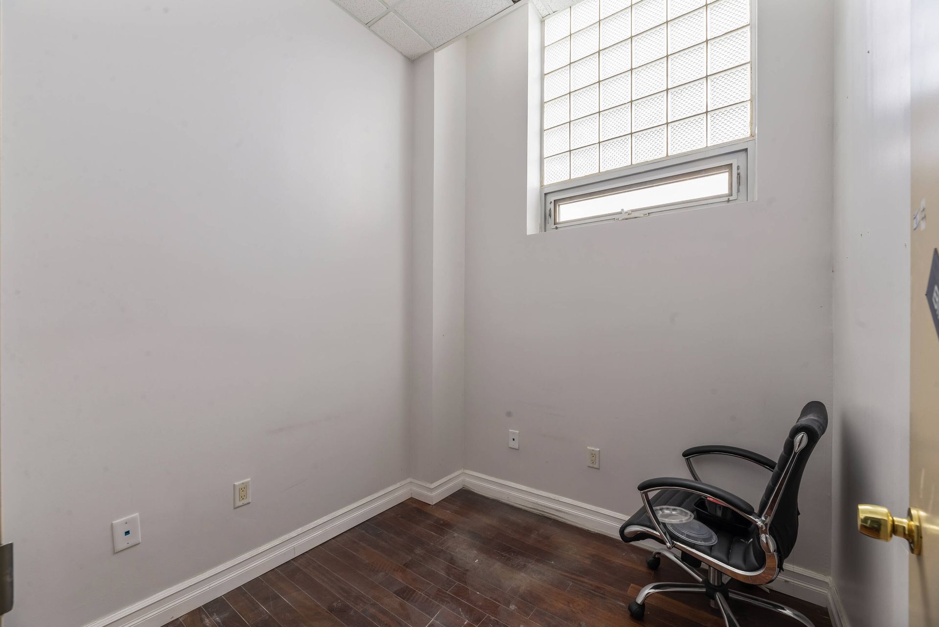 An empty room with a chair and a window.