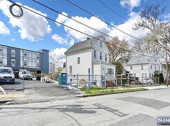 A white house is sitting on the corner of a street.