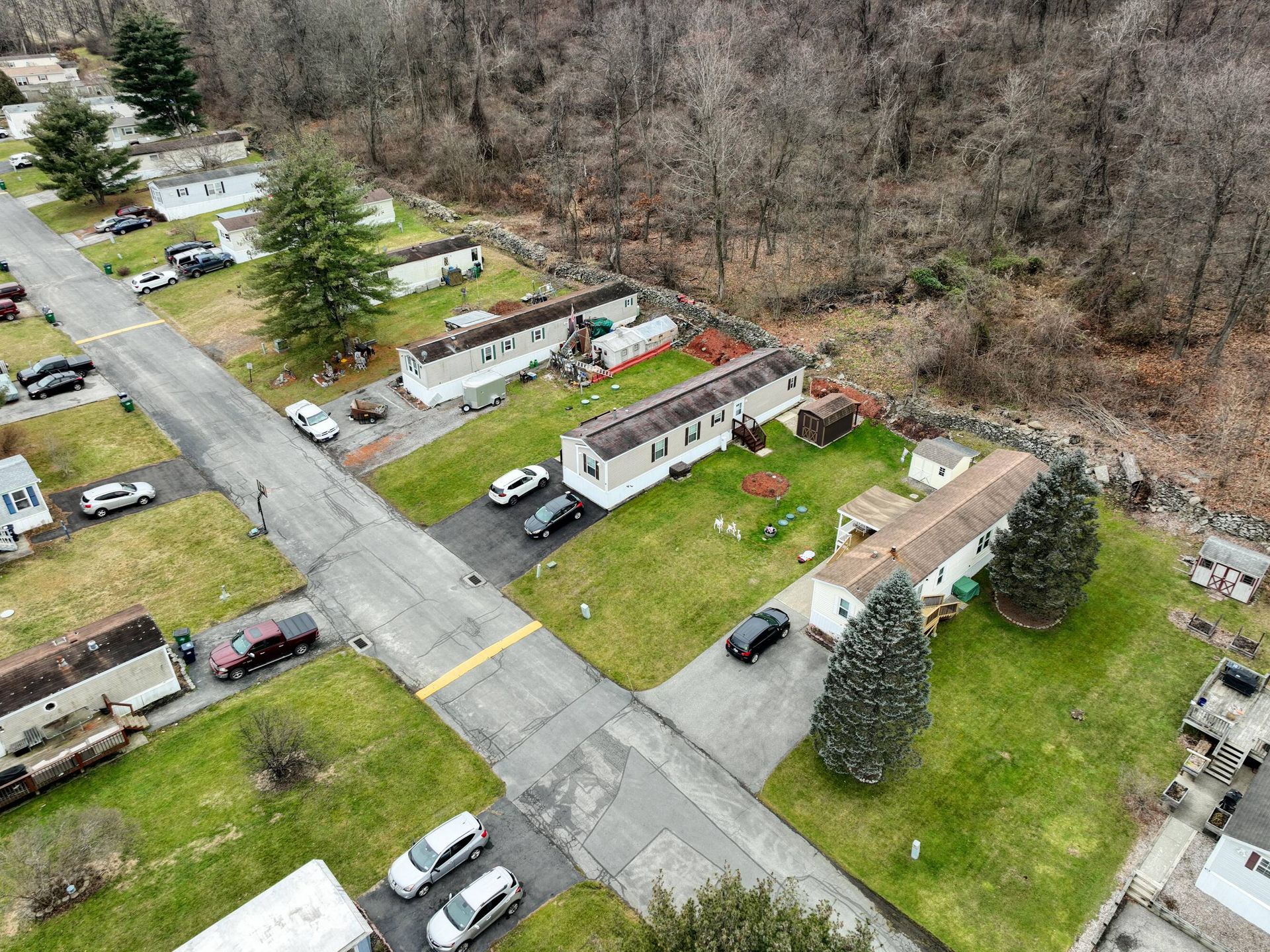 An aerial view of a mobile home park with a lot of cars parked on the side of the road.