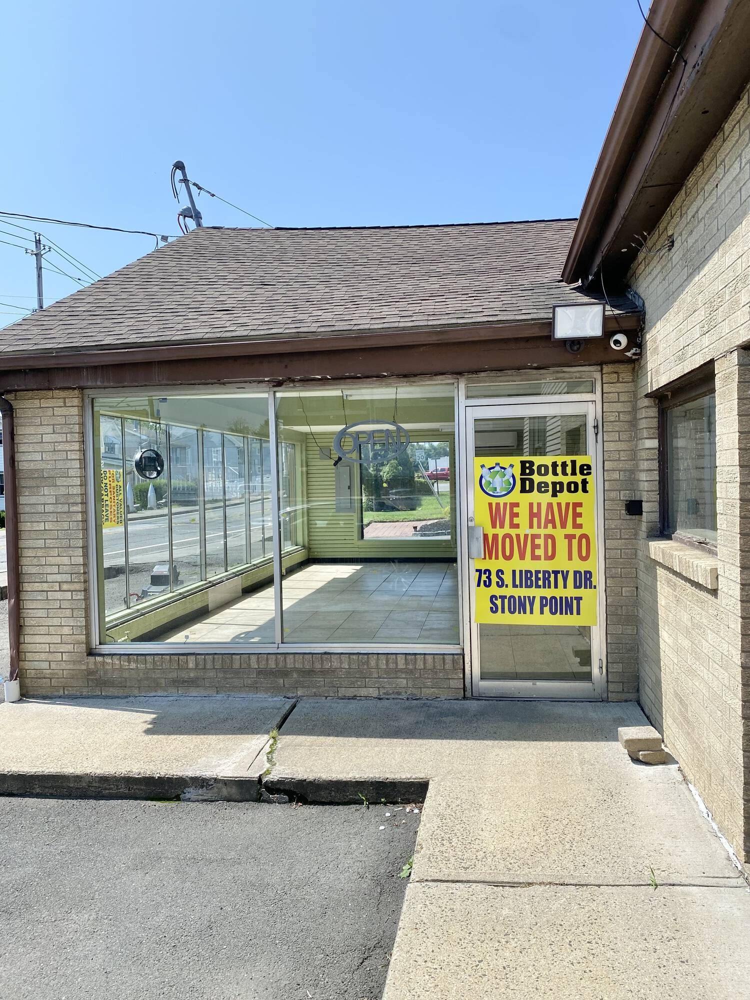 A brick building with a sign on the door that says `` we have moved to ''.