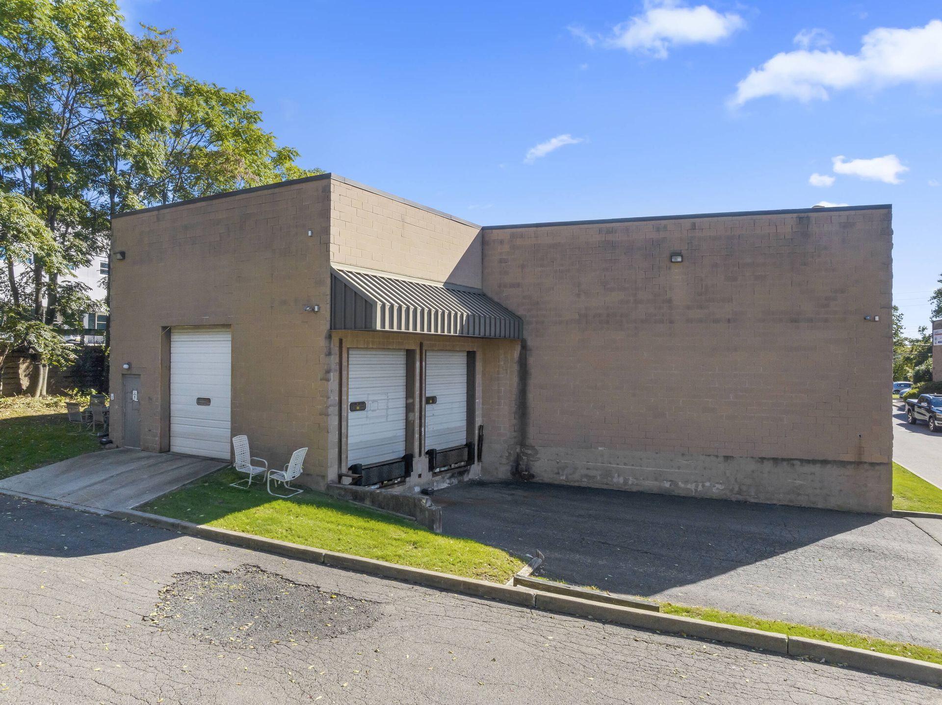A large brick building with two garage doors and a canopy.