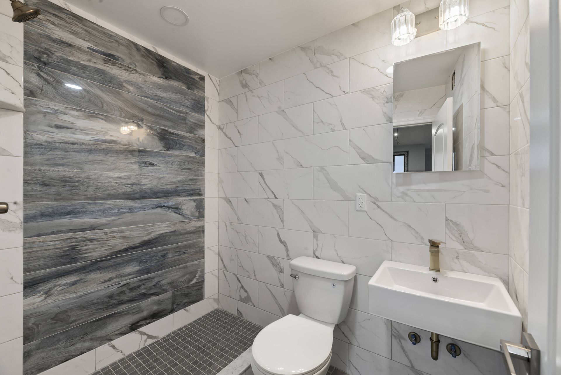 A bathroom with a toilet , sink and shower.