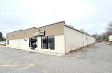A large building with a lot of windows and a parking lot in front of it.