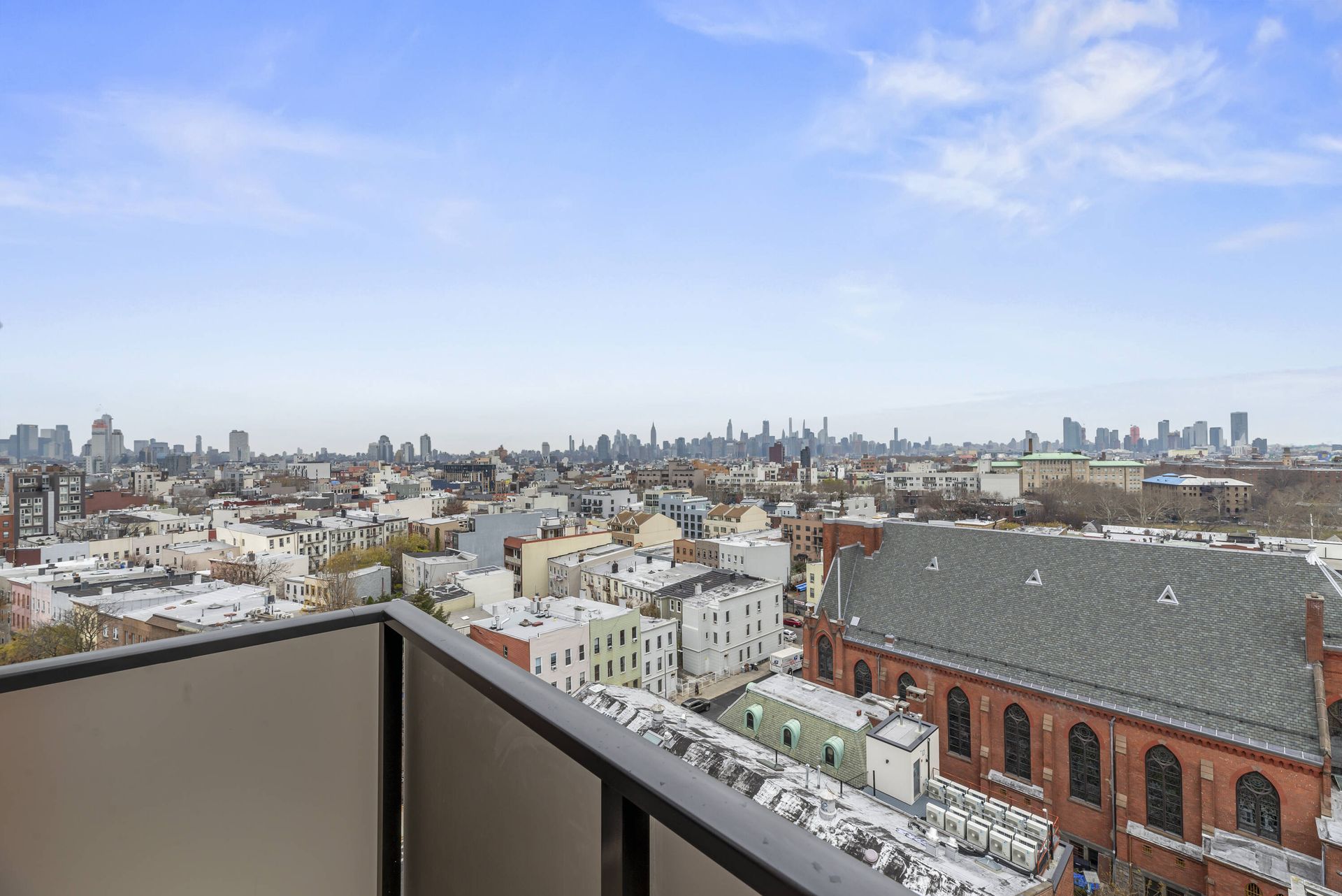 A balcony with a view of a city and a church.
