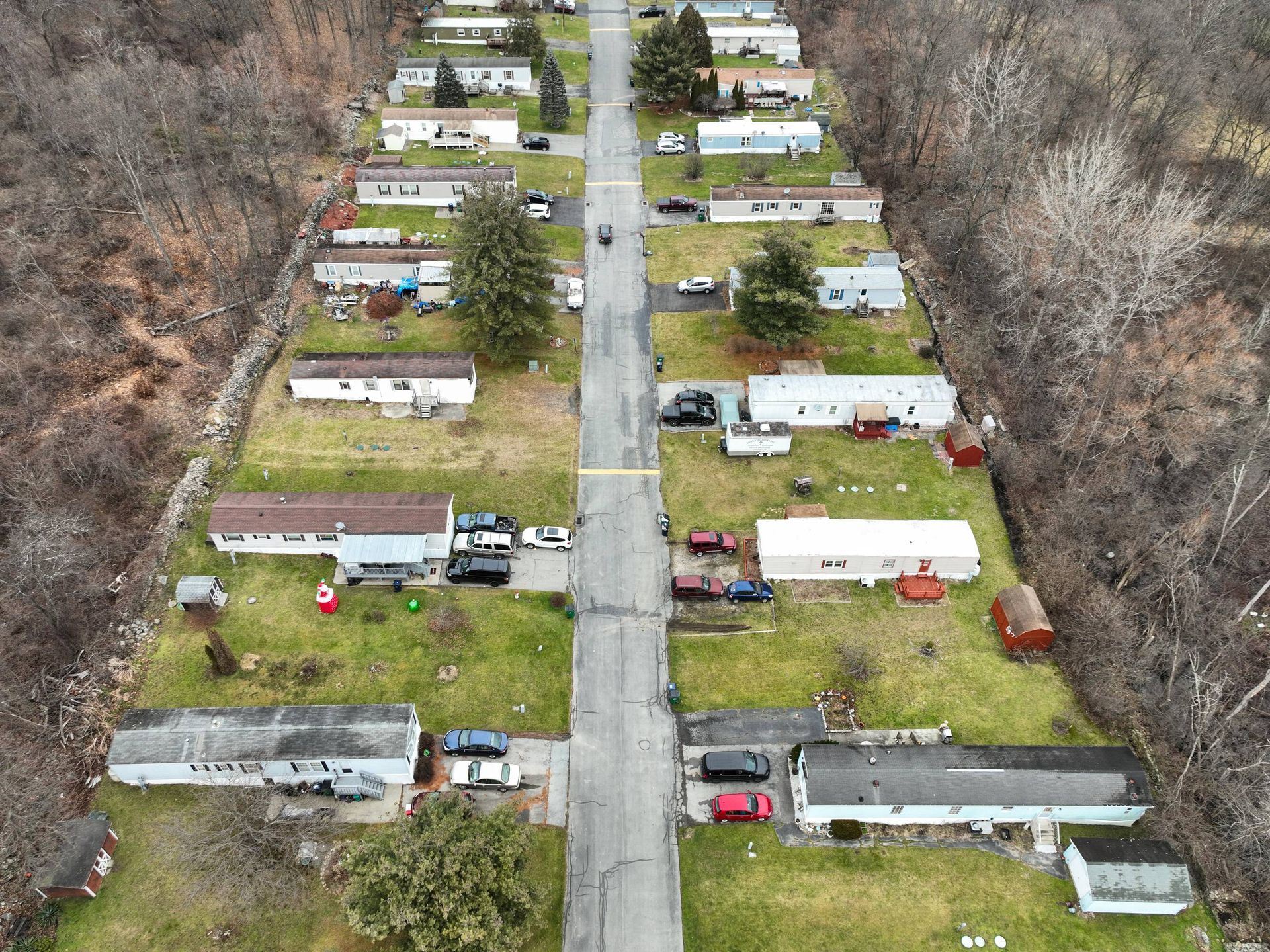 An aerial view of a mobile home park with a road going through it.