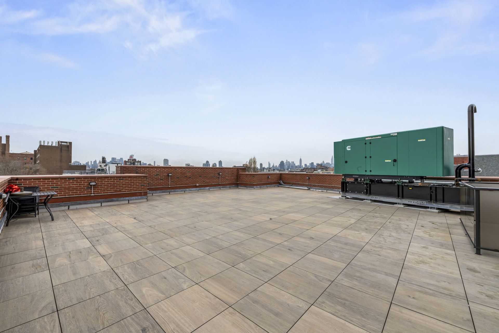 A rooftop deck with a green generator on top of it