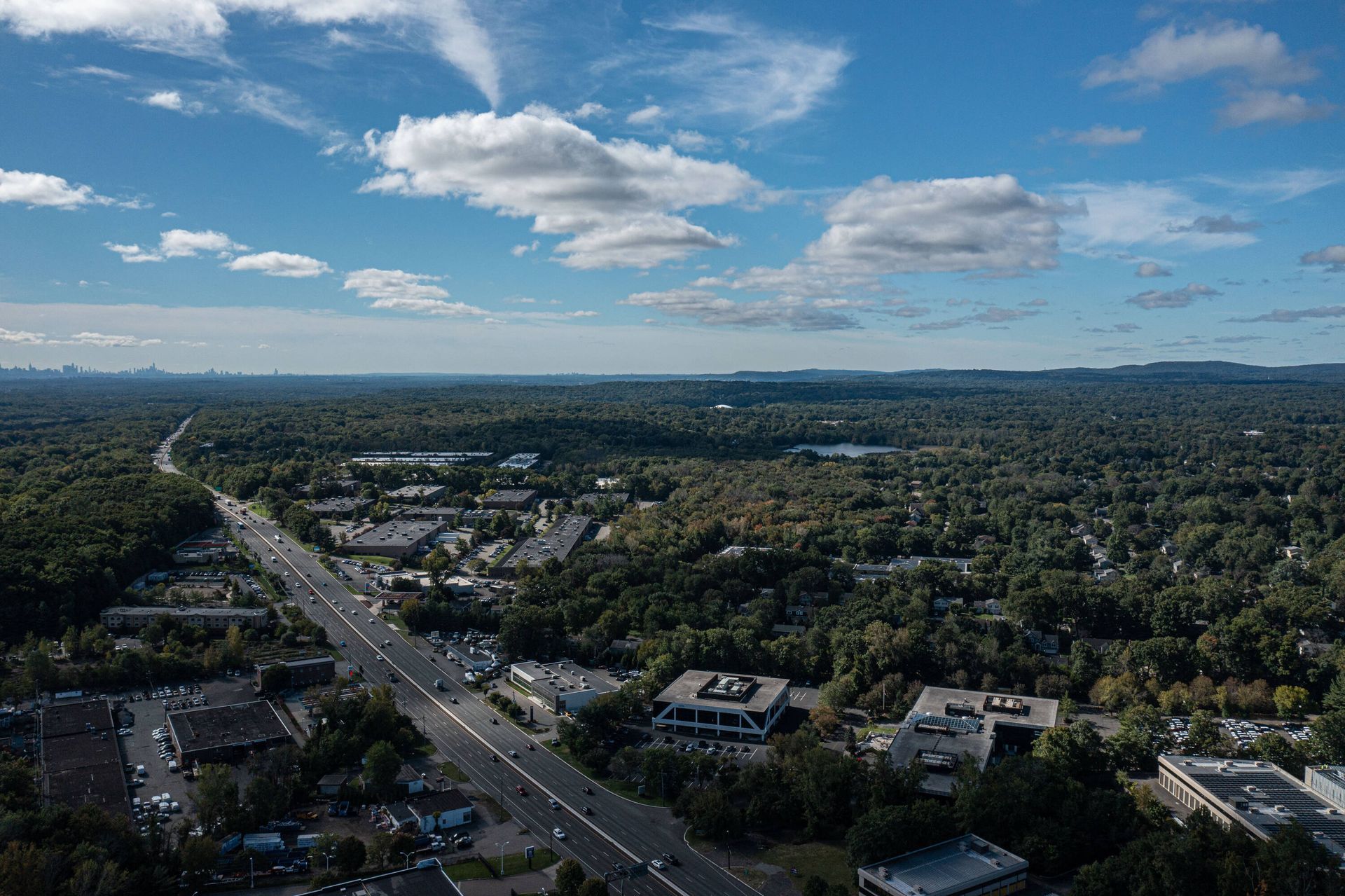 An aerial view of a city surrounded by trees and buildings on a sunny day.
